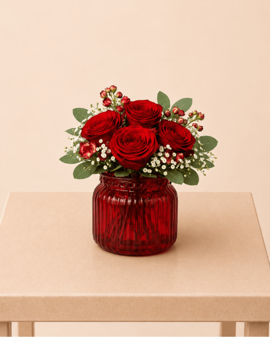 Red Romance Vase ™ - A romantic flower arrangement featuring premium red roses, accented with delicate spray roses, fresh baby’s breath, and soft eucalyptus greenery. Beautifully designed in a striking red glass vase, this piece brings warmth, love, and timeless elegance to any space.  Perfect for Valentine’s Day, anniversaries, romantic gestures, birthdays, or adding a touch of elegance to any space or special celebration.  Available for local flower delivery throughout Naples, Bonita Springs, Estero, Fort Myers and Fort Myers Beach.  Designer’s Choice: Each arrangement is uniquely designed using the freshest seasonal flowers available. Flower varieties, colors and containers may vary while maintaining the overall style, value and beauty of the design.