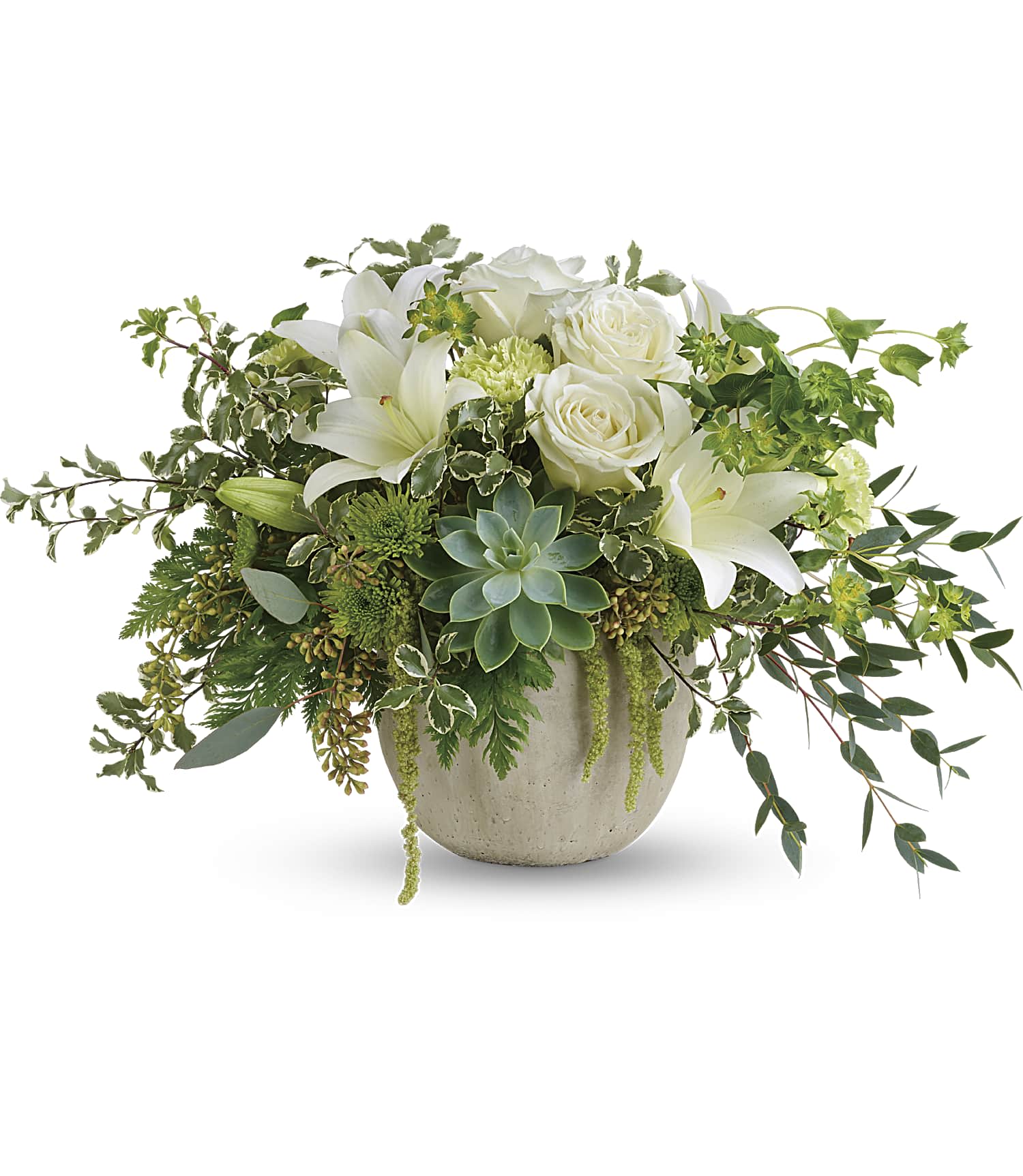 White roses and lilies in a low ceramic vase with trailing greenery
