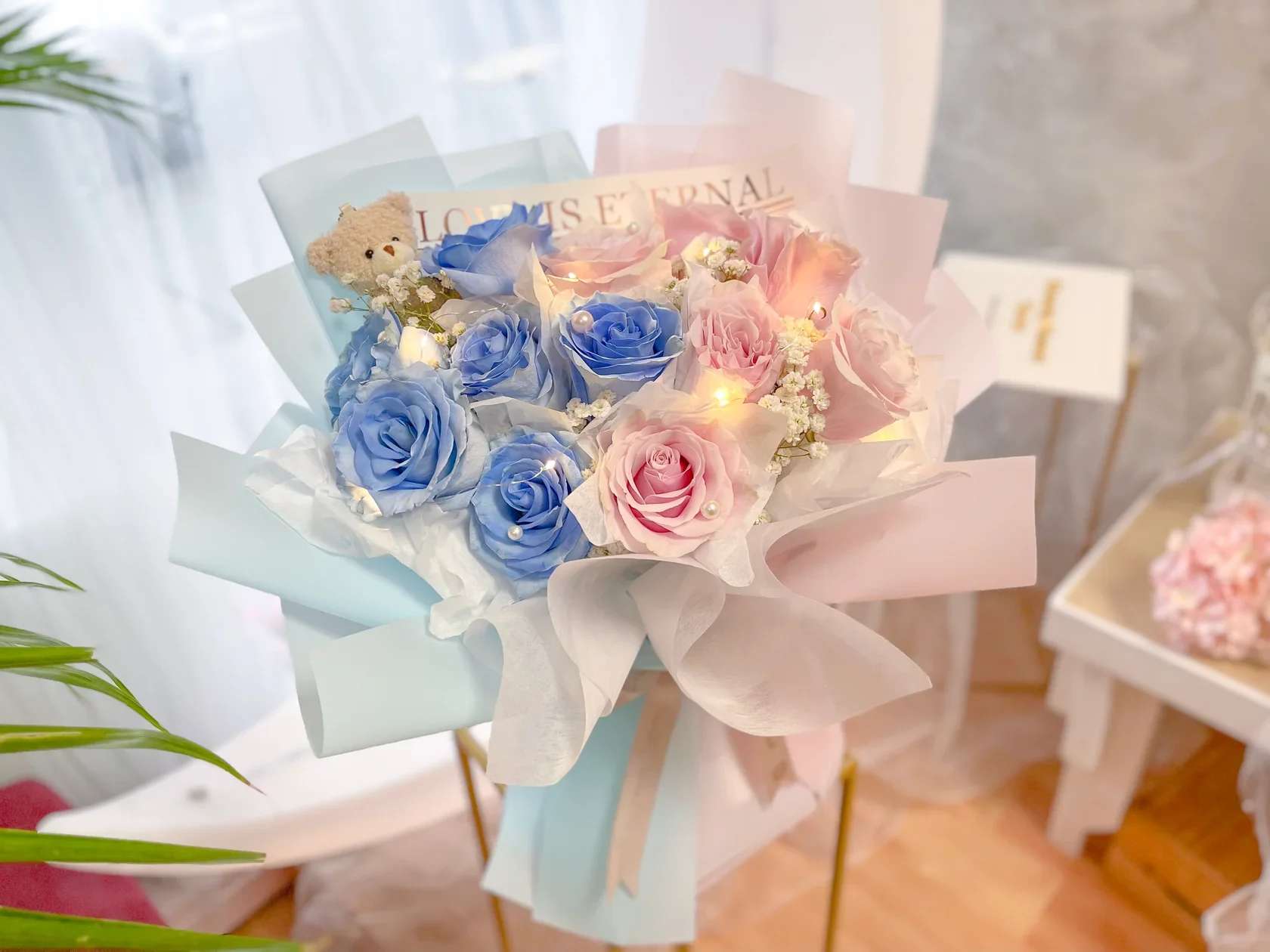 Bouquet of blue and pink roses with a small teddy bear