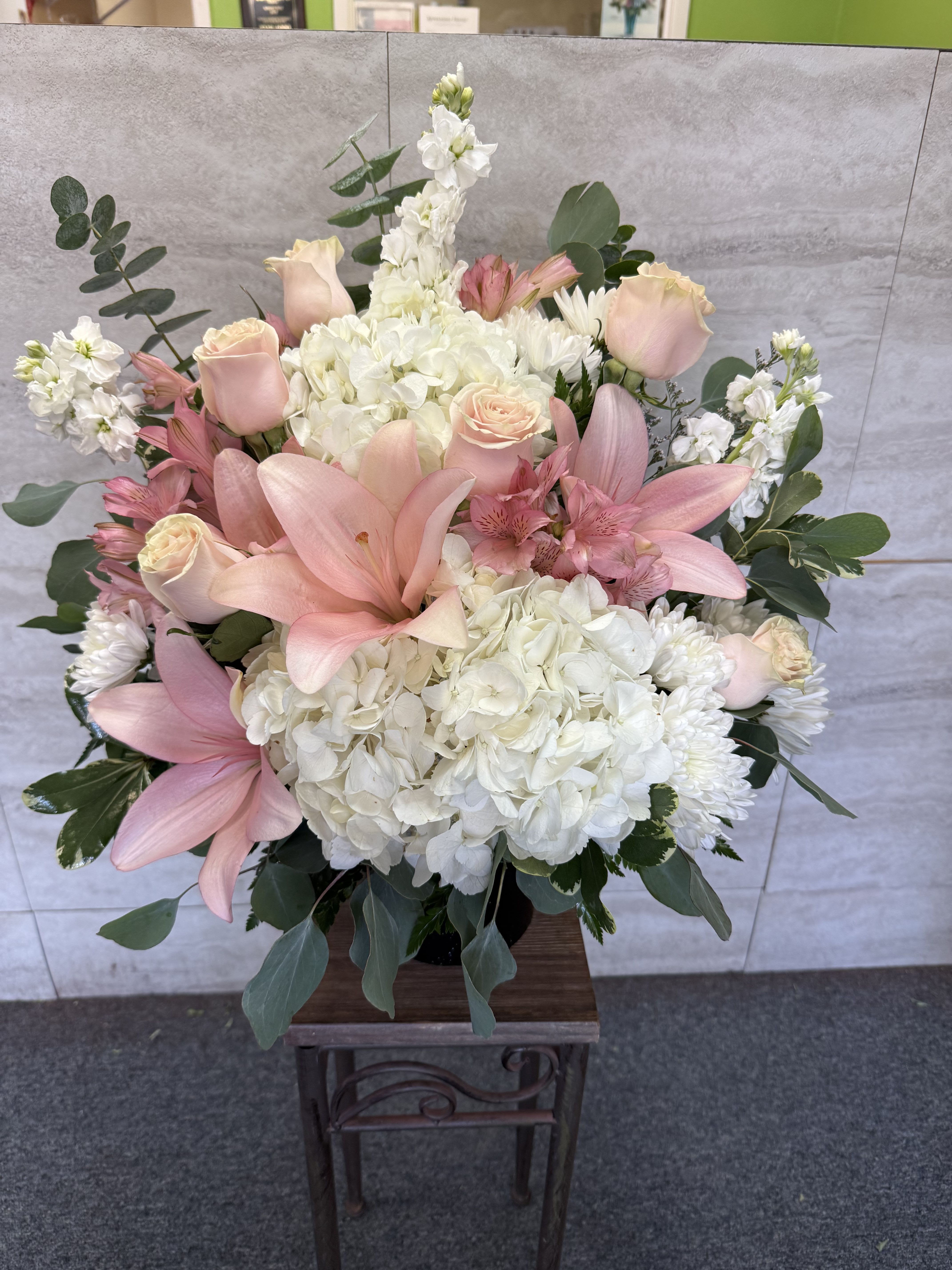 Pink lilies and roses with white hydrangeas in a vase