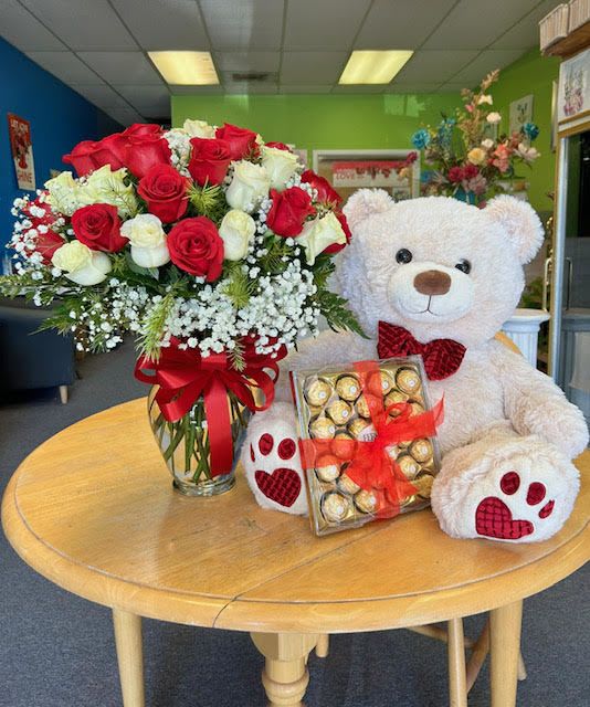 Red and white rose bouquet with a teddy bear and chocolates