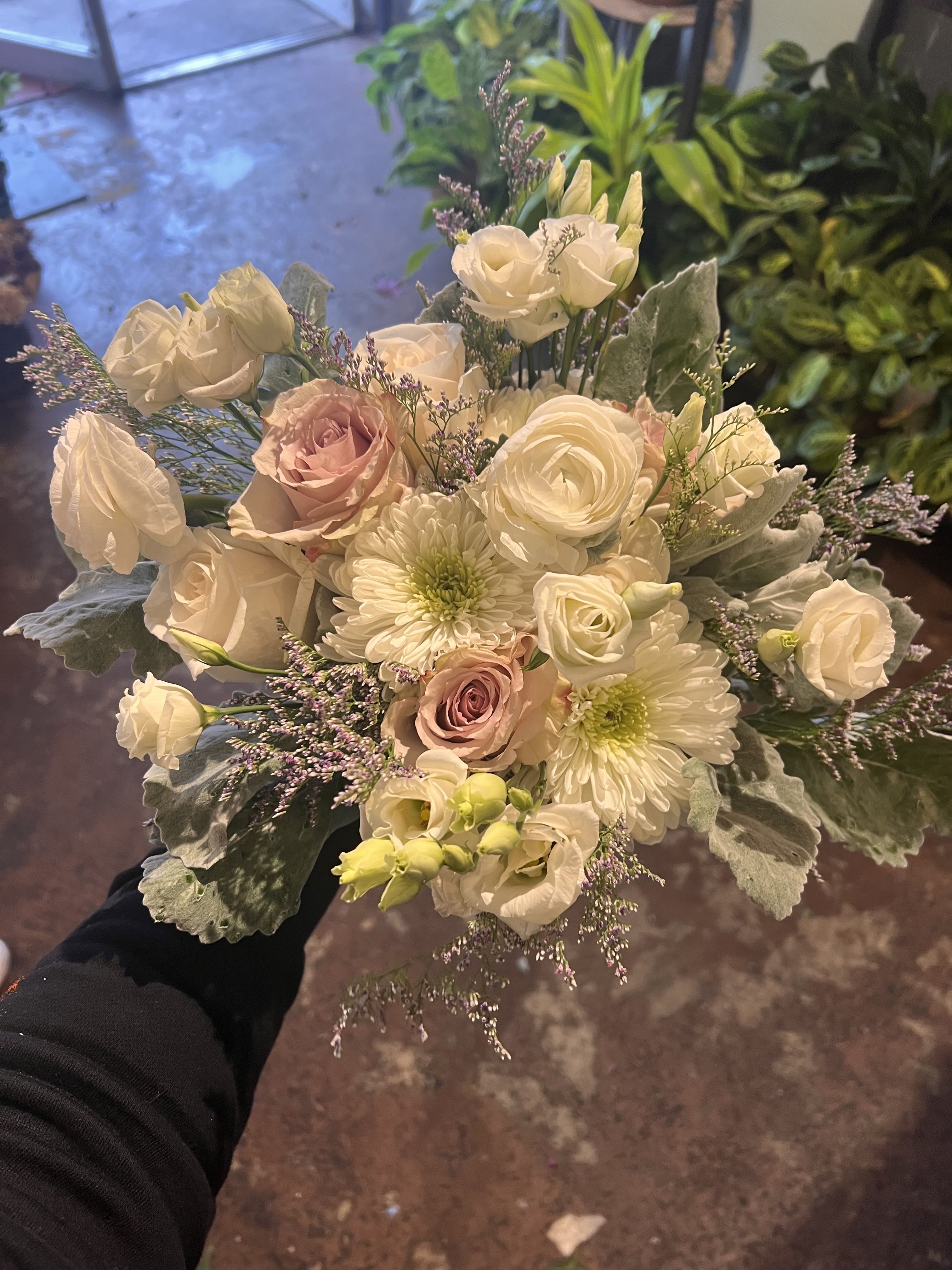 Champagne Pearl - Ivory petals like poured silk, muted champagne roses, and whispering accents of lilac and silver create a palette worthy of a Parisian atelier. Champagne Seraph feels celestial, weightless, and meticulously styled — a bouquet that elevates rooms, moments, and hearts with effortless sophistication.