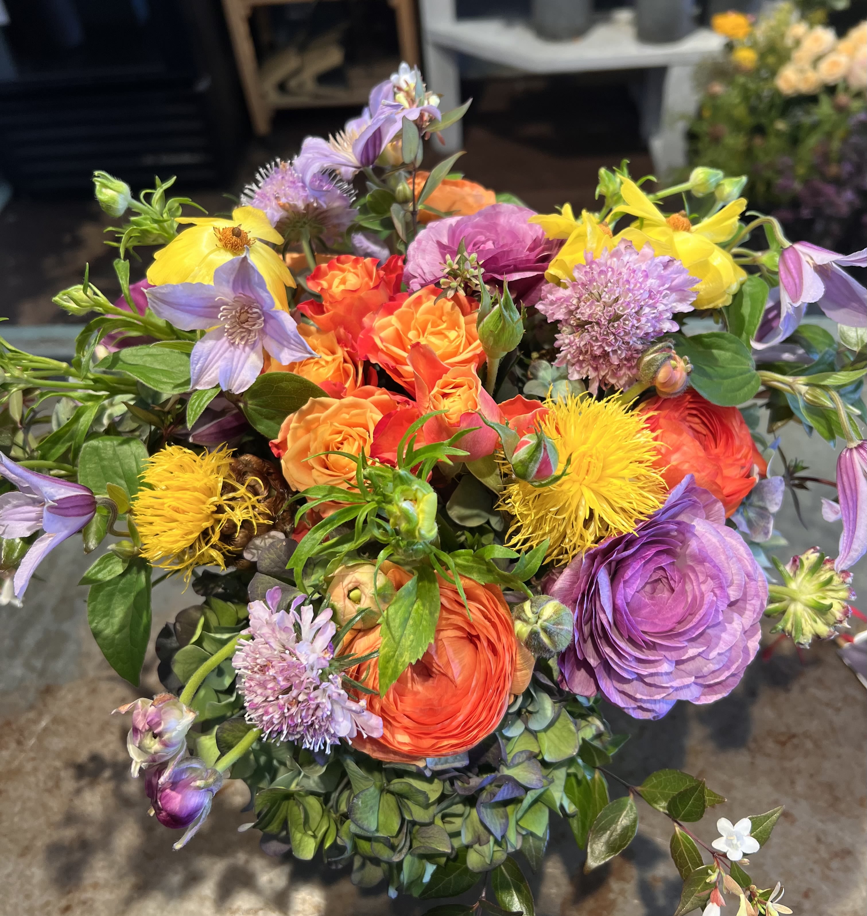 The Ranunculus &amp; Silk Collection - A refined luxury floral collection highlighting premium ranunculus, clematis, and seasonal garden blooms. Designed with an organic, artful approach, each arrangement features lush layers, natural movement, and rich color stories in coral, golden yellow, violet, and soft lavender. Handcrafted using high-quality flowers and textured botanicals, this collection is ideal for weddings, statement events, and elevated gifting. Created for clients who appreciate bespoke floral design, modern elegance, and exceptional craftsmanship. 