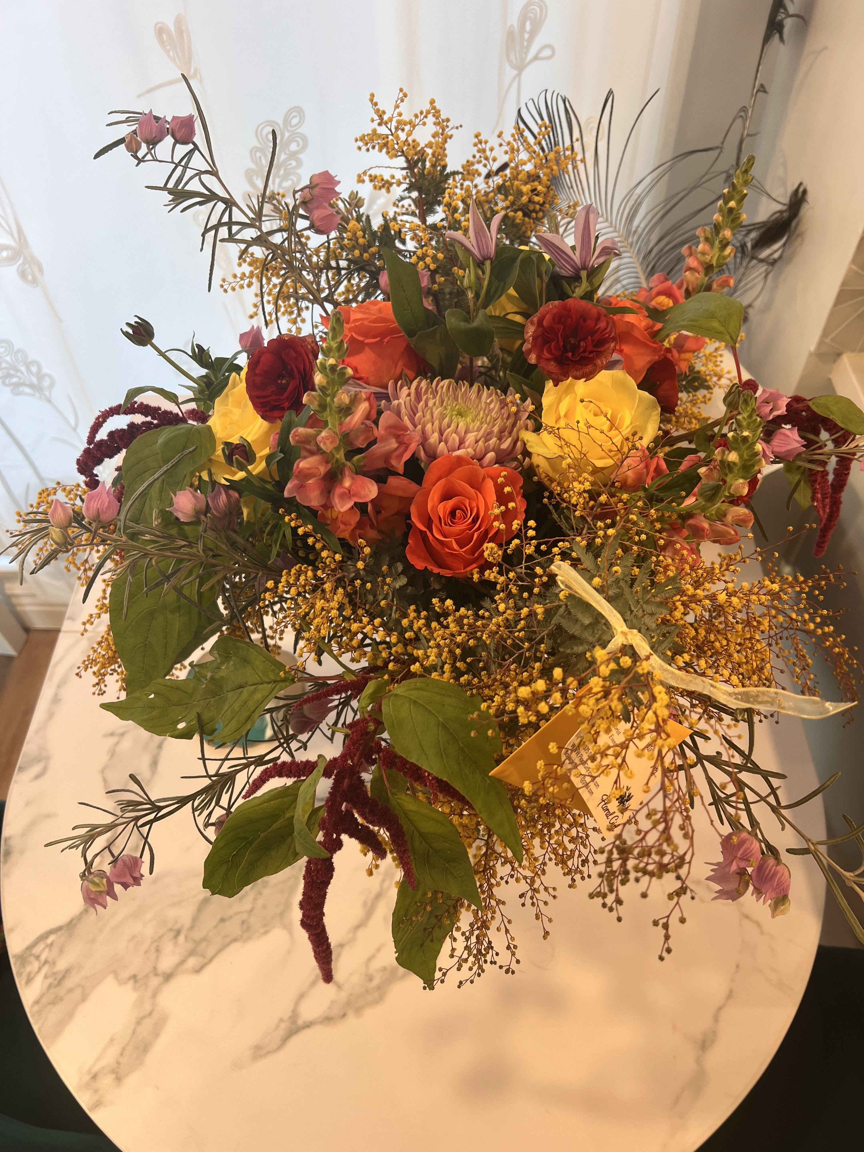 Golden Harvest Garden - Golden Harvest Garden is a lush, garden-style floral arrangement designed with premium seasonal blooms in warm autumn tones. Featuring rich reds, soft blush flowers, golden textures, and natural greenery, this handcrafted design offers organic movement and timeless elegance. Perfect for birthdays, anniversaries, fall celebrations, or sending a meaningful gift, each arrangement is thoughtfully created using the freshest flowers available.