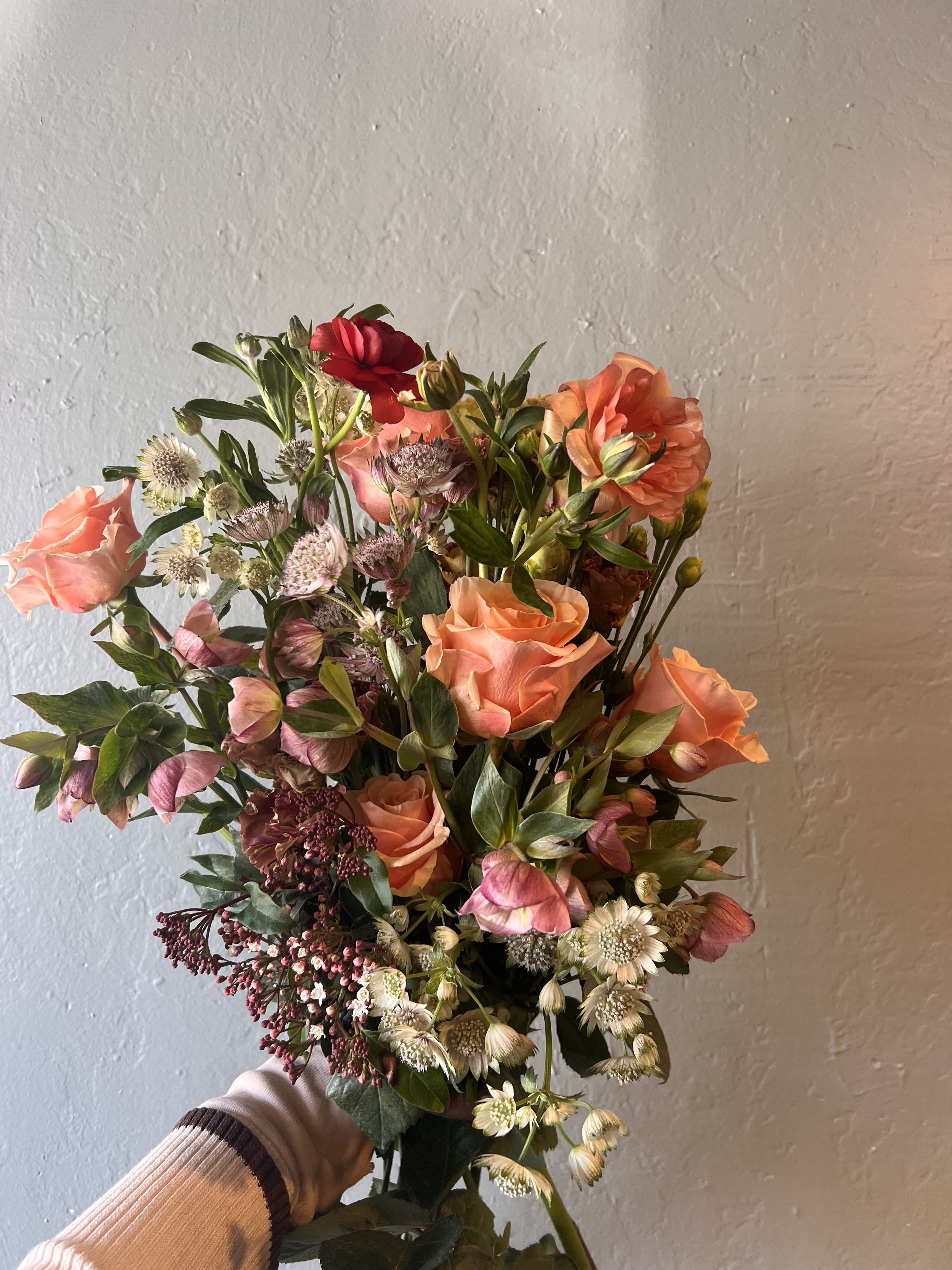 Coral Petal Garden  - Coral Petal Garden is a sophisticated garden-style floral arrangement featuring premium seasonal blooms in warm peach, coral, blush, and soft rose hues. Designed with natural movement and layered texture, this luxury bouquet highlights elegant roses, hellebore, ranunculus, and delicate accent flowers, artfully arranged to create a refined yet organic silhouette.  Handcrafted by a professional florist, Coraline Rosée is ideal for anniversaries, birthdays, romantic occasions, and elevated everyday flower delivery. Each arrangement is uniquely designed using the freshest flowers available, offering a bespoke floral experience that embodies femininity, warmth, and timeless luxury.