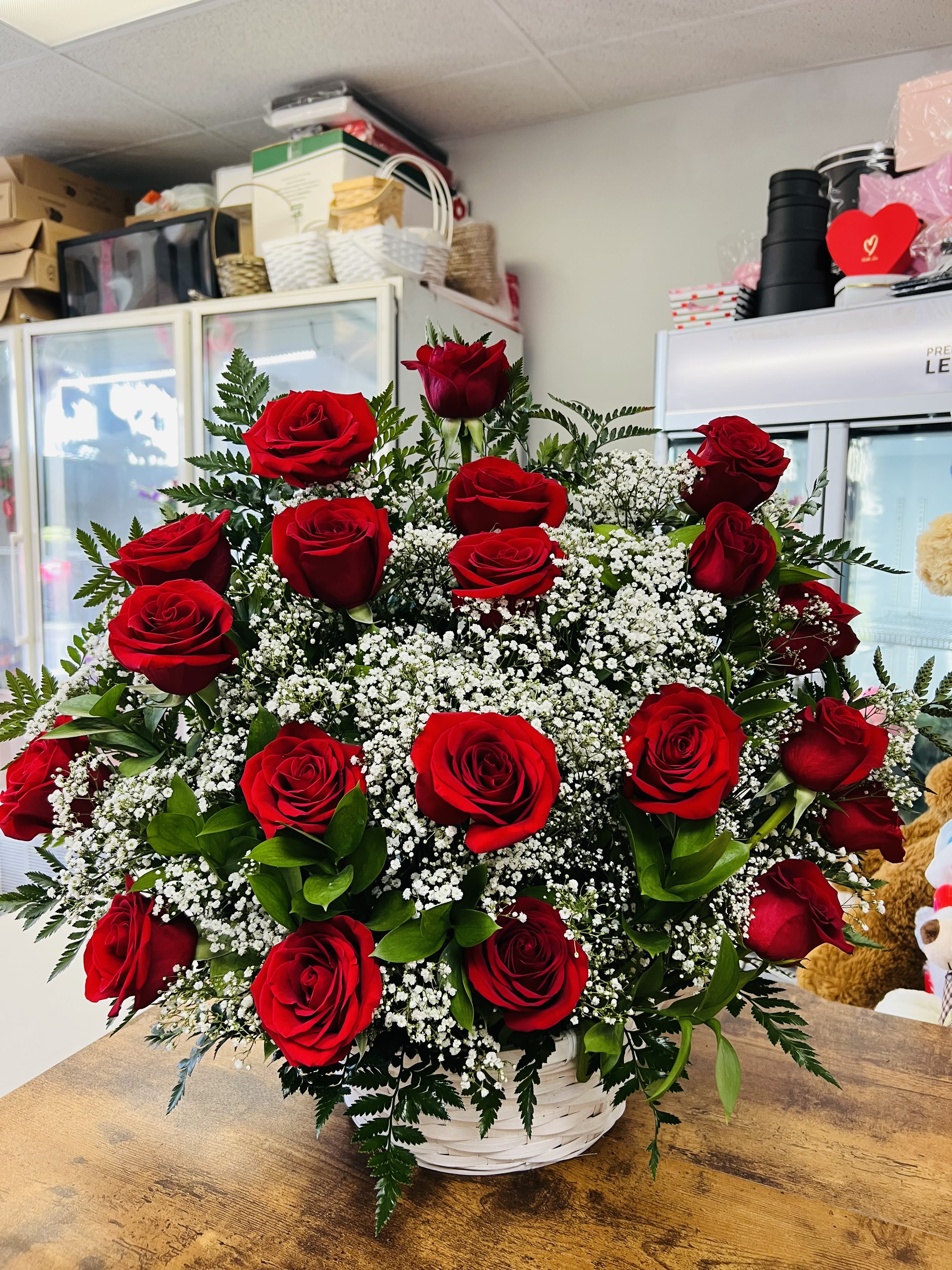 Basket arrangement of red roses with white filler flowers
