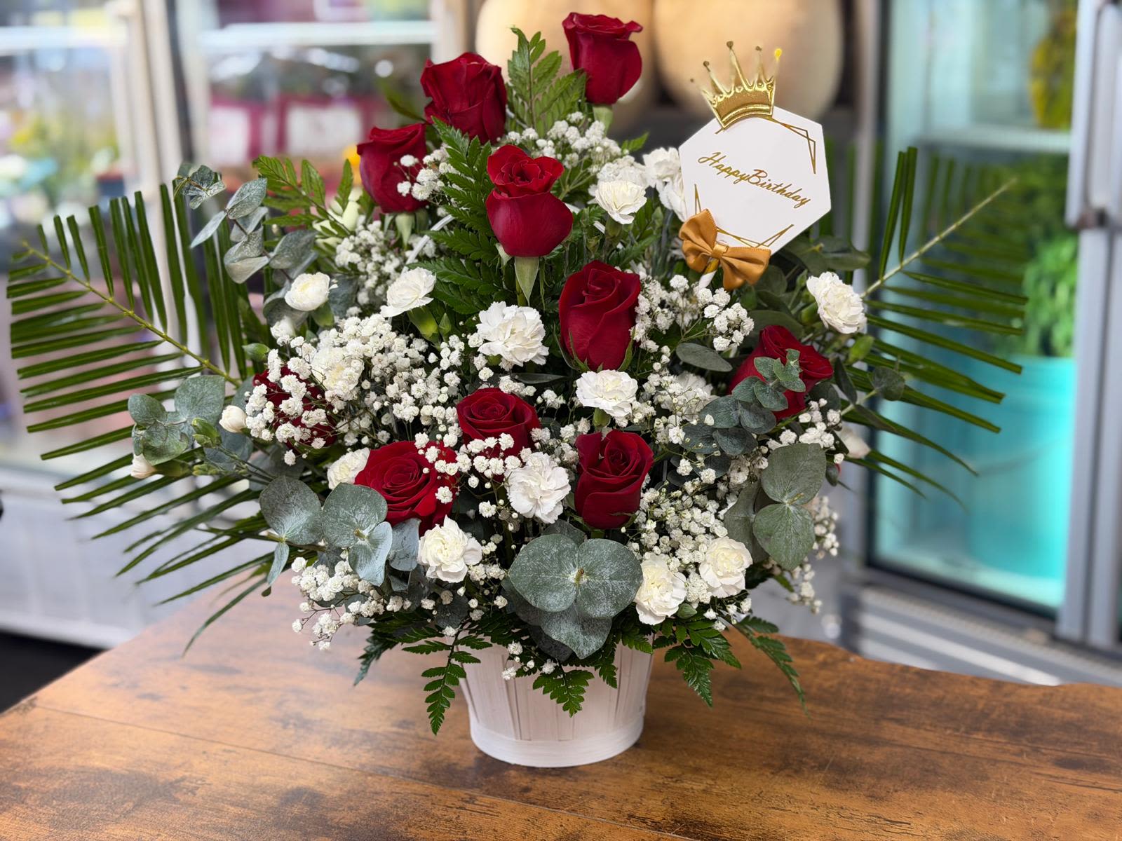 Red and white roses in a white pot with a birthday tag