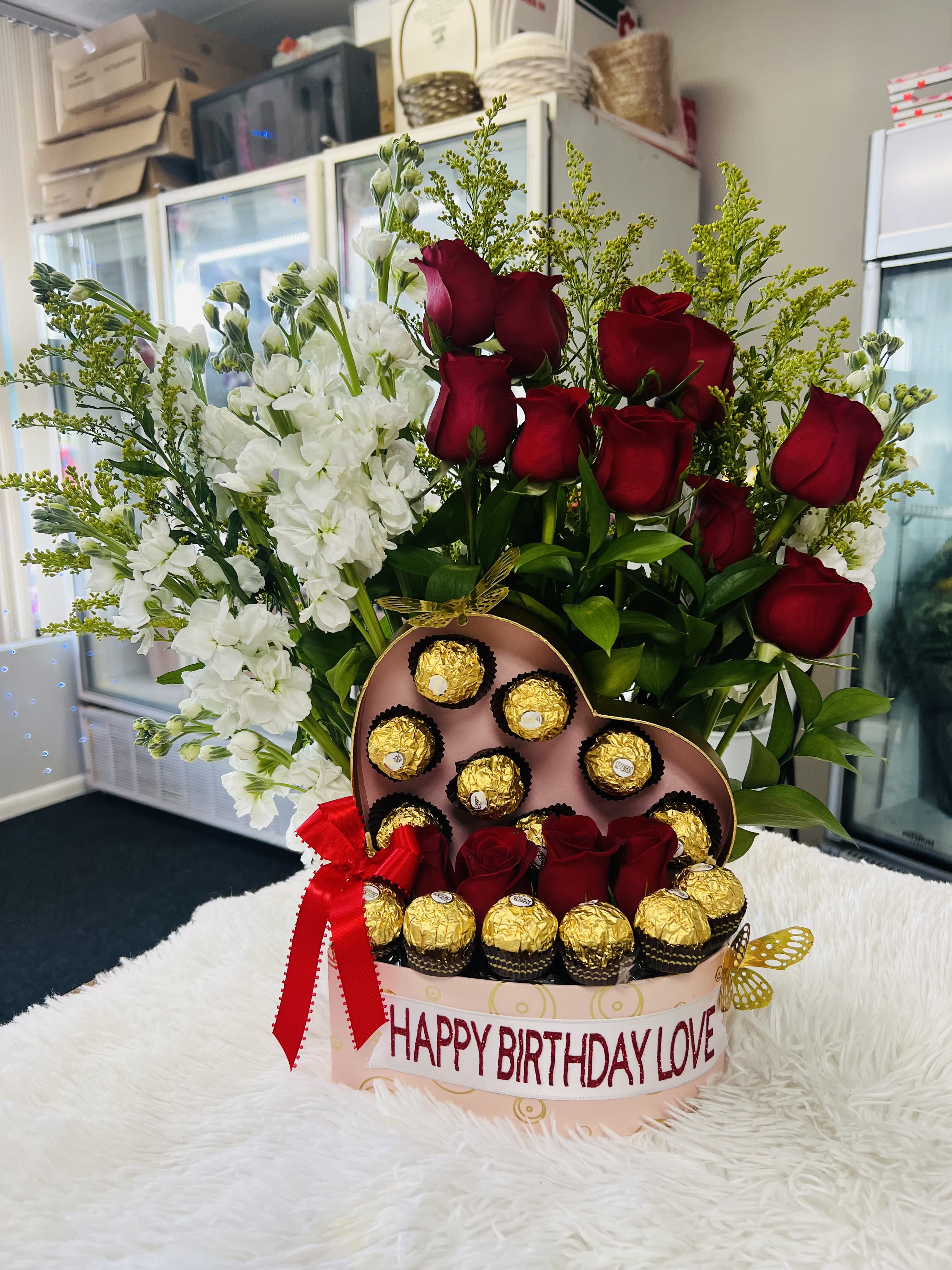 corazón de amor  - arreglo hecho en caja en forma de corazón con flores y chocolates cinta personalizada