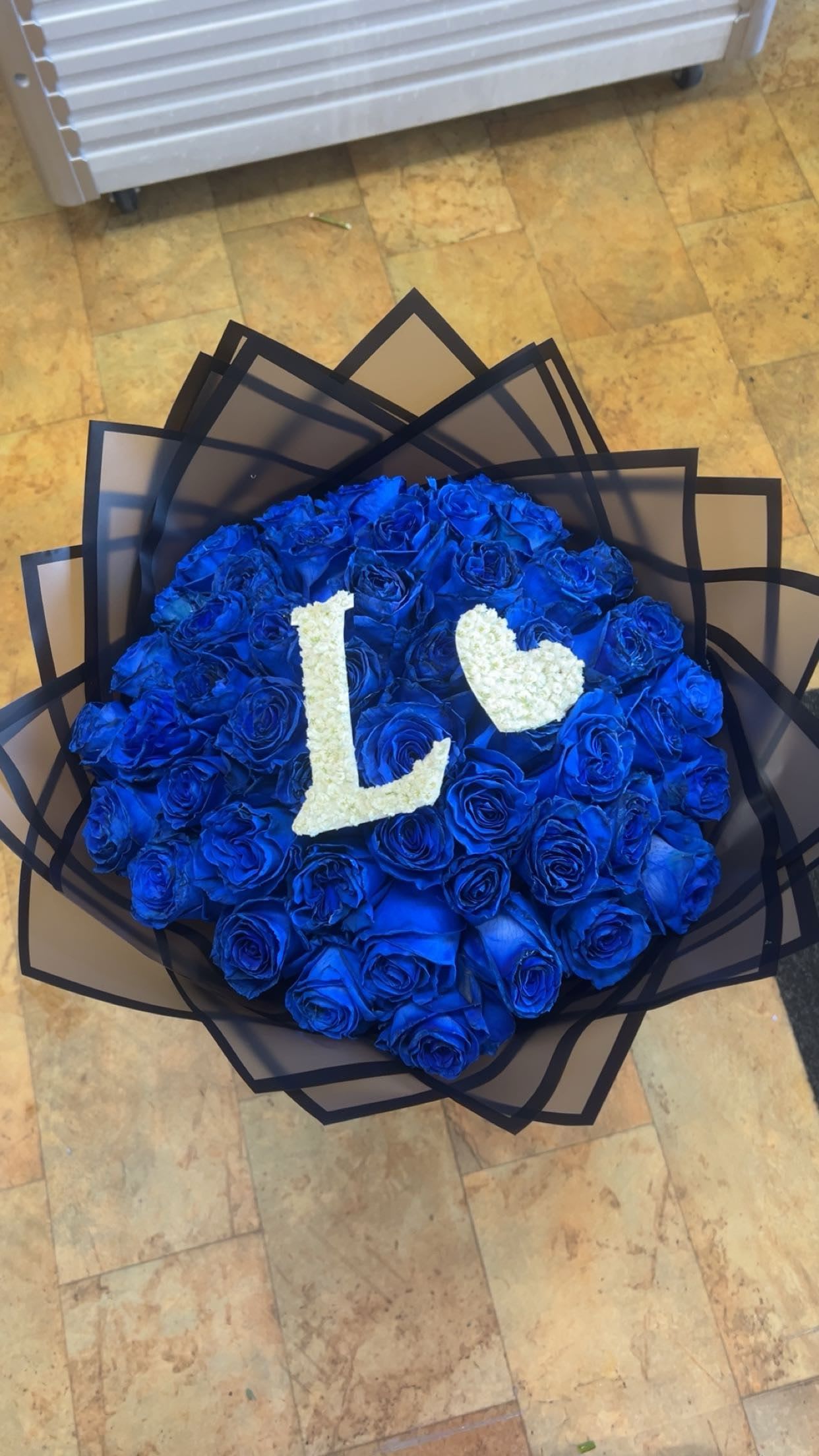Round bouquet of blue roses with white floral letters and heart