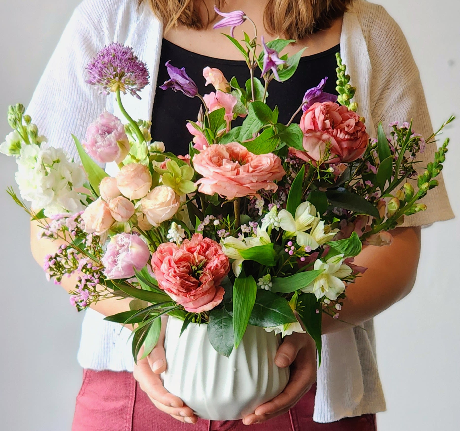 Medium Spring Garden Collection - A lush, garden-inspired design filled with soft spring blooms in a romantic palette of blush, peach, creamy whites, and hints of lavender. Designed with natural movement and layered textures, this arrangement feels as if it was freshly gathered from a blooming spring garden.  Delicate ranunculus, ruffled tulips, airy stock, and seasonal accents are thoughtfully arranged in a ceramic vessel, creating an effortless and organic look that’s both elegant and full of life.  Perfect for celebrating the beauty of the season, sending love, or brightening any space with fresh, soft spring color.  *Flowers and vases are natural and artisan products, and no two arrangements are exactly alike. While your arrangement may differ slightly from the photo, it will be designed with the same style and color palette of your choice. Occasionally, substitutions of vases may be necessary due to market availability, but we will always substitute with a vase of equal or greater value.
