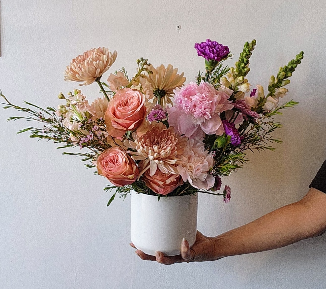 Large Spring Garden Collection-Soft &amp; Elegant - An abundant, garden-style arrangement designed with lush layers of soft spring blooms in romantic shades of peach, blush, buttery tones, and pops of lavender. With a wider, more expansive shape, this design is filled with movement and texture, creating the feeling of a flourishing spring garden in full bloom.  Featuring premium seasonal flowers like ranunculus, garden roses, peonies, and delicate accents, each arrangement is thoughtfully styled in a ceramic vessel for a natural, effortless look.  Perfect for making a statement, celebrating meaningful moments, or filling a space with the beauty and softness of spring.  *Flowers and vases are natural and artisan products, and no two arrangements are exactly alike. While your arrangement may differ slightly from the photo, it will be designed with the same style and color palette of your choice. Occasionally, substitutions of vases may be necessary due to market availability, but we will always substitute with a vase of equal or greater value.
