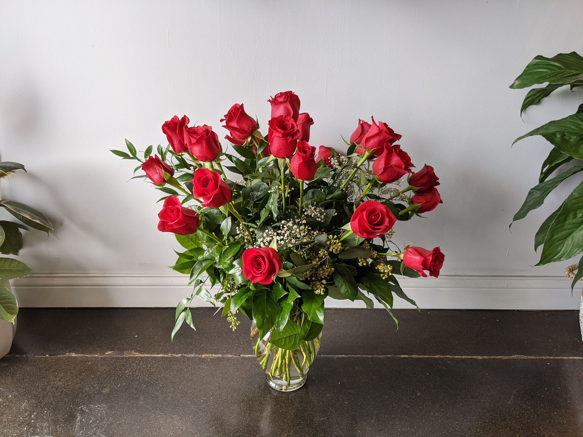 Red roses arranged in a clear glass vase
