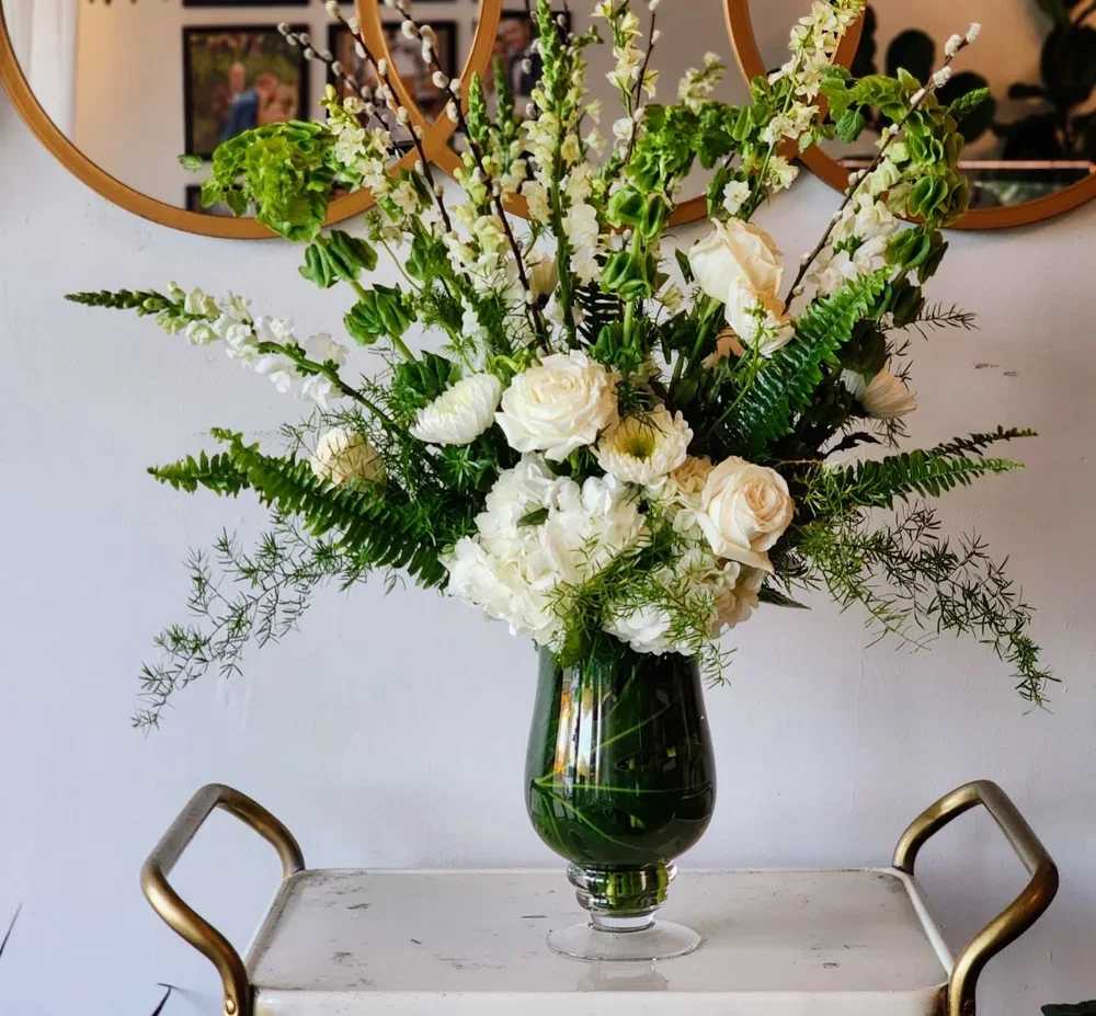 White floral arrangement in a dark glass vase