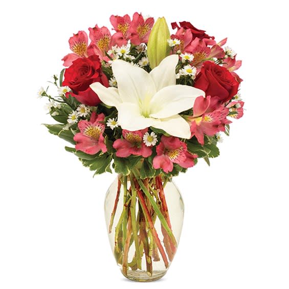 Bouquet of red roses, pink alstroemeria, and white lilies in a glass vase