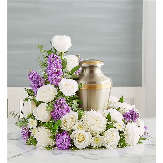 White and purple floral arrangement around a metal urn