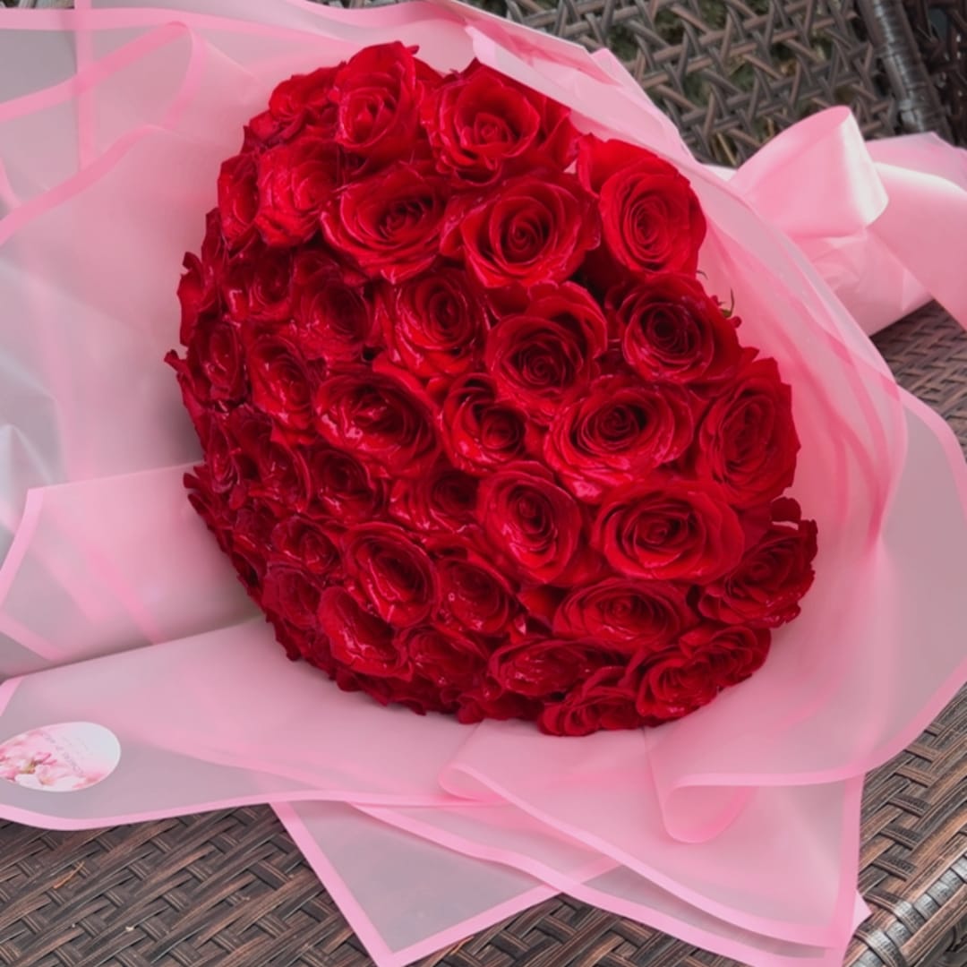 Bouquet of red roses wrapped in pink paper