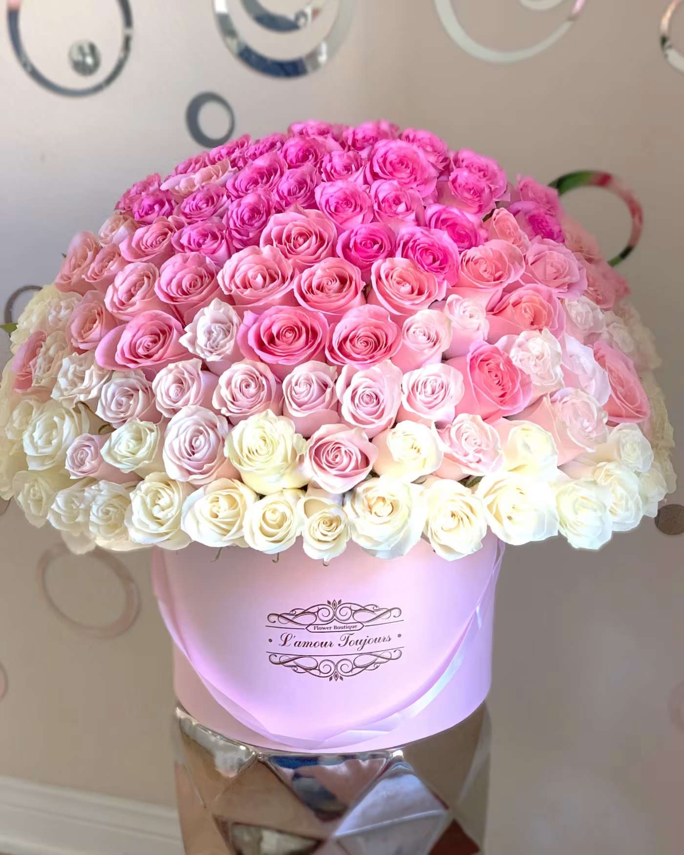 Large bouquet of pink and white roses in a pink hat box