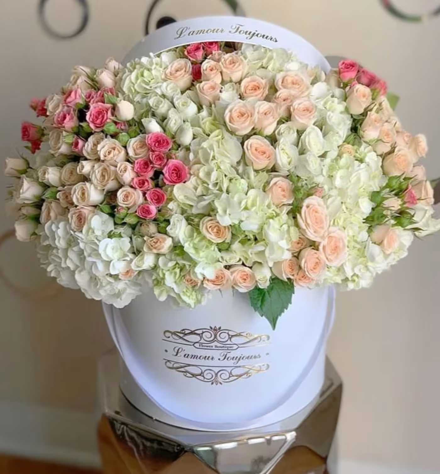 Large bouquet of pale pink and white roses in a white hat box