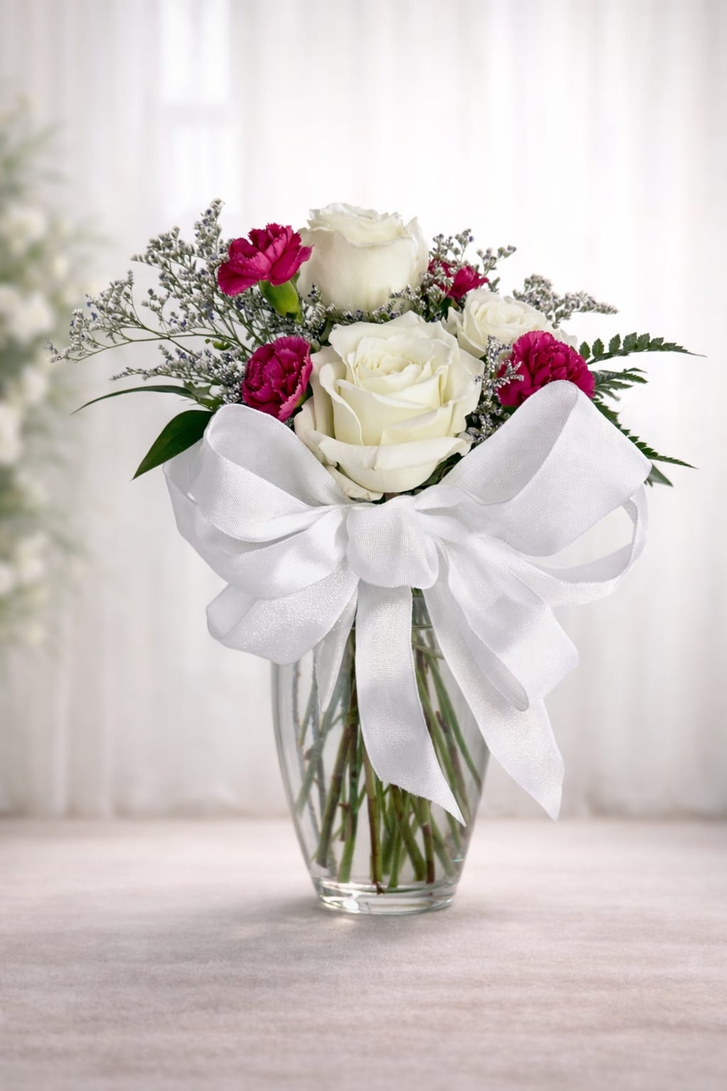 A little pick me up - 3 roses, mini carnations, baby’s breath and greenery. Colors may vary. 