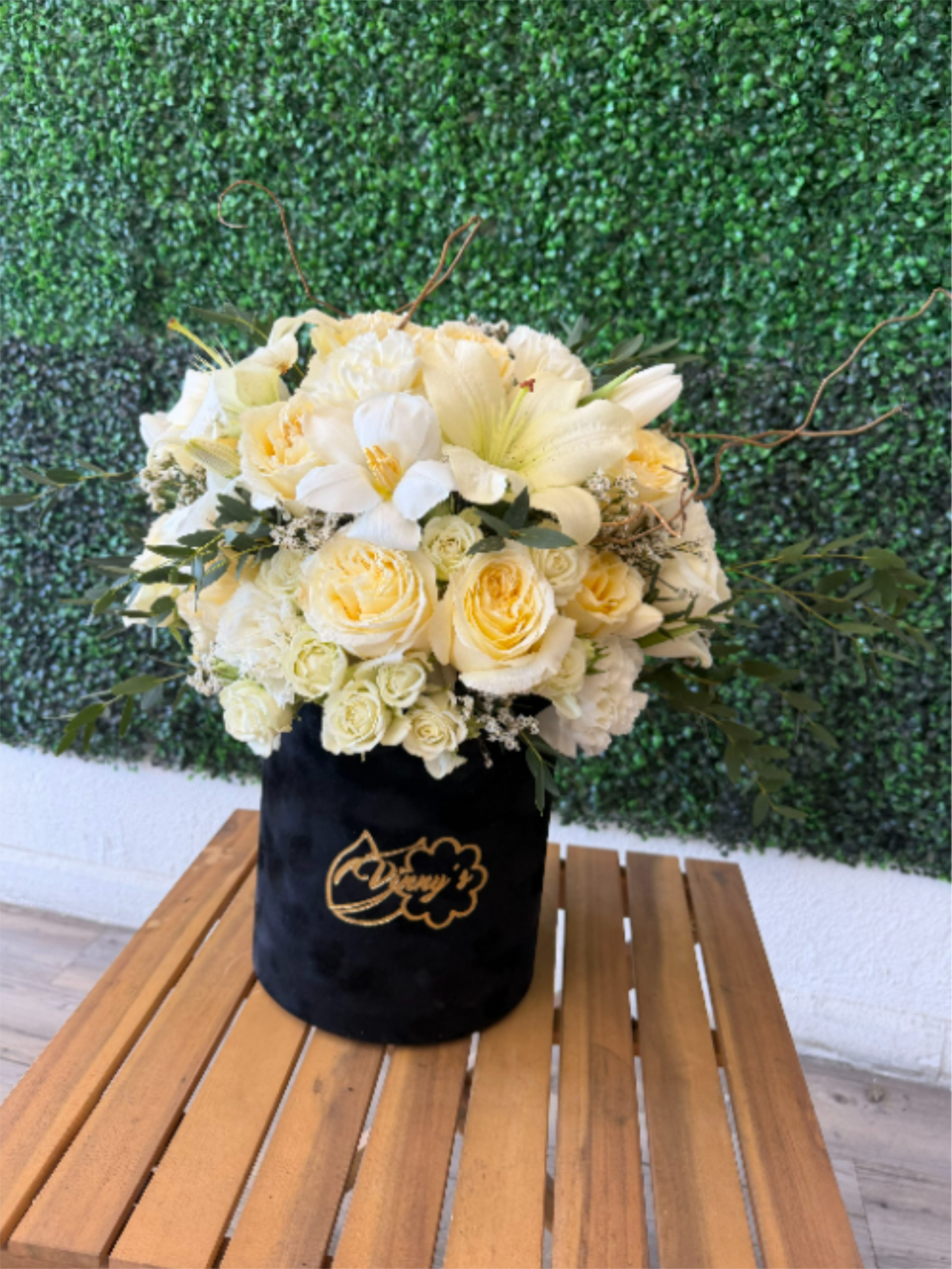 Cream and white flower arrangement in a black velvet box
