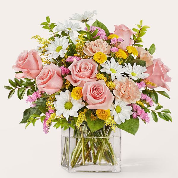 Pink roses and white daisies in a clear glass vase