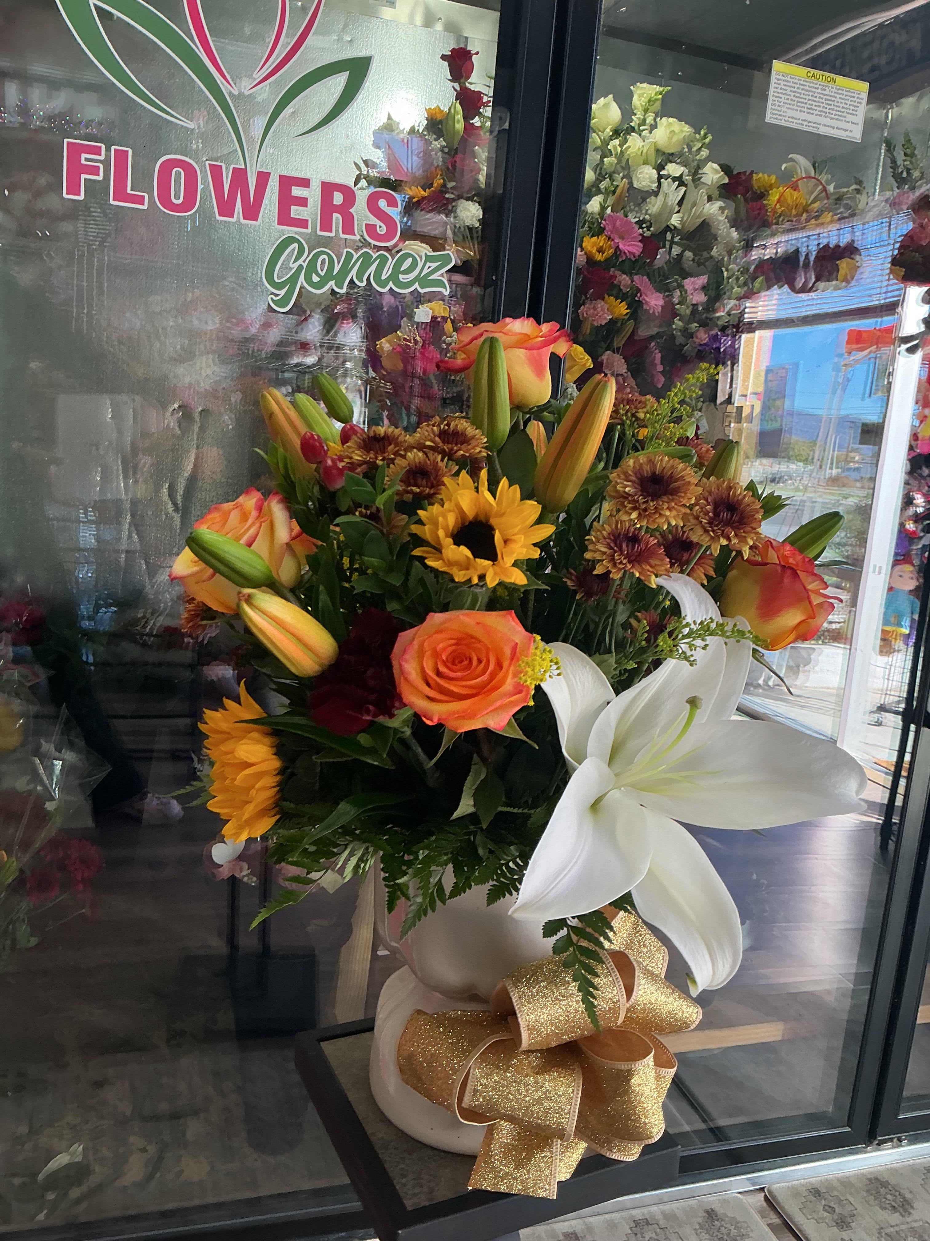 Peaches  - This cute arrangement is a must have made of orange roses , lovely white lillies , brown daisys and  beautiful sunflowers, green leather giving you a cute gold bow 