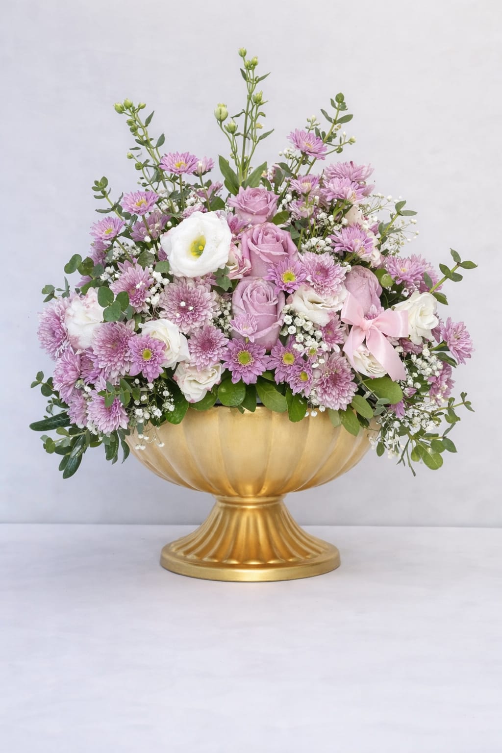 Blush Royale - Blush Royale is a luxury garden-style floral arrangement designed in an elegant gold pedestal vase. Featuring premium blush and lavender roses, soft pink chrysanthemums, white lisianthus, baby’s breath, and fresh seasonal greenery, this tall and full arrangement makes a stunning statement.  Perfect for birthdays, anniversaries, Mother’s Day, celebrations, or elegant home décor. Handcrafted by a local florist in Carlsbad, California, each arrangement is thoughtfully designed with high-quality blooms and a soft romantic color palette.  Available for same-day or next-day flower delivery in Carlsbad and North County San Diego.