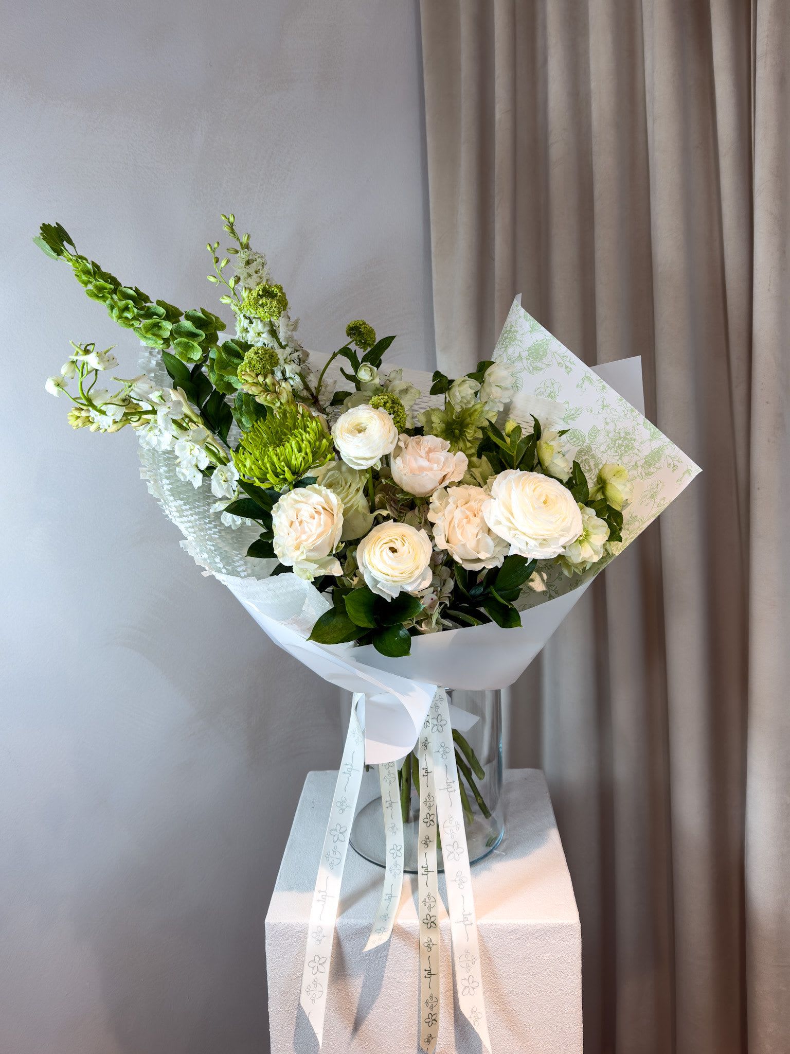 Ilsaek Kkot Monochromatic Bouquet - Our Monochromatic Bouquet will be arranged per color palette. With your choice of color, we will assemble a Petal Designer’s Choice bouquet in that color. Hand-selected assortment of the freshest seasonal blooms, thoughtfully arranged and elegantly wrapped in Korean-style wrapping for a modern, artistic presentation. Each bouquet is completely unique - colors, textures, and flowers vary with the season and availability, ensuring that no two bouquets are ever the same.   Every bouquet includes a handwritten note, which comes with care instructions for your blooms.  All bouquets come with a carry-out bag, and bouquets of 24 stems or more include a water pouch in addition to the bag for easy transport.  PLEASE NOTE:  Delivery orders should be placed 2-3 days in advance. For same-day delivery, please call or text us at 704.975.2774 to check availability.  FINAL SALE POLICY:  All orders are final sale. Due to the custom and perishable nature of our floral designs, we are unable to accommodate cancellations, refunds, or exchanges once an order has been placed. Each arrangement is made uniquely for you, with care and attention to detail.  Images are for inspiration only - we do not replicate past designs or recreate another florist’s work. Each bouquet is handcrafted with creativity, intention, and care.