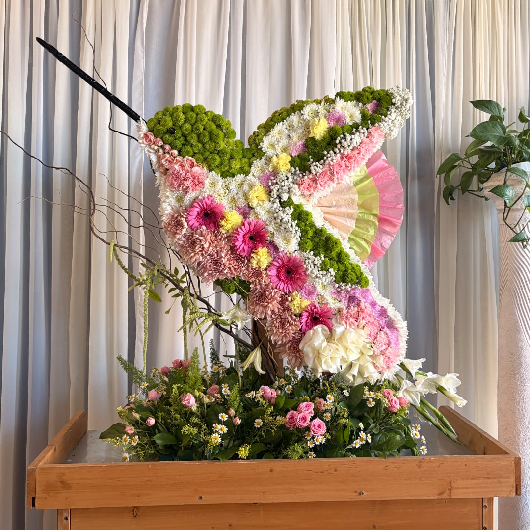 Large floral butterfly display with pink, white, and green flowers
