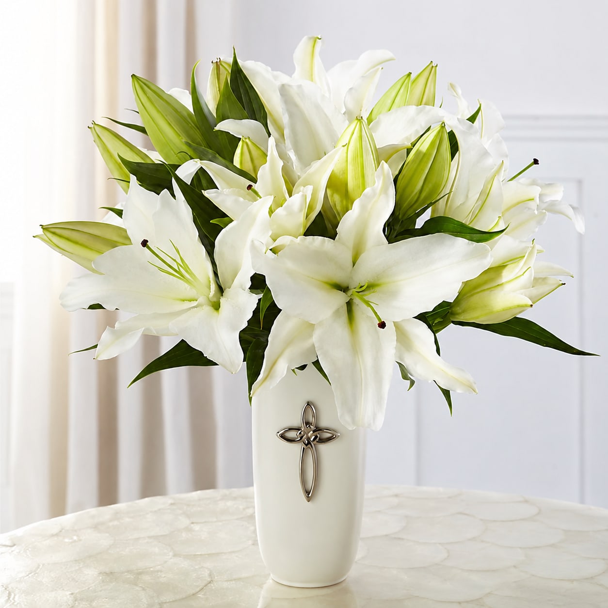 Faithful Blessings - The Faithful Blessings Bouquet is an incredible way to celebrate a communion, confirmation, or wedding, as well as send your sympathy for the loss of a loved one. Bringing together stems of fragrant Oriental Lilies, boasting multiple blooms on each stem to create a full and lush flower bouquet, this offering of flowers will bring peace and beauty to any of life's special moments and occasions. Presented in a keepsake designer white ceramic vase with a stunning cross on the front, this exquisite flower arrangement exudes heartfelt blessings with each eye–catching, star–shaped lily.
