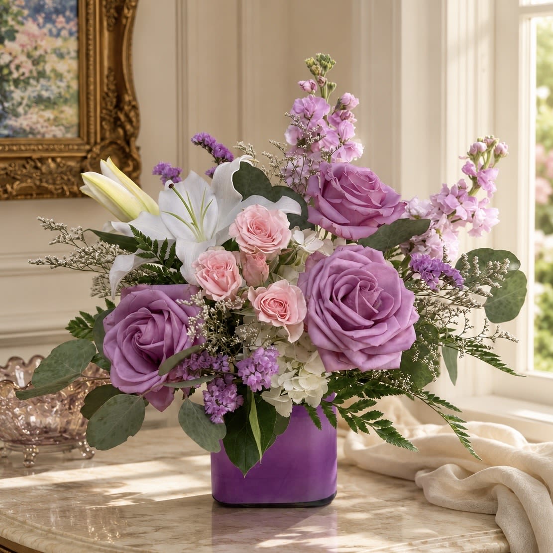 Serene Dream - No matter the occasion this soft and serene color palette is sure to please. Pink and lavender roses, fragrant stock and lilies, delicate filler are arranged in a lavender cube vase. The perfect way to show someone they are in your thoughts. 