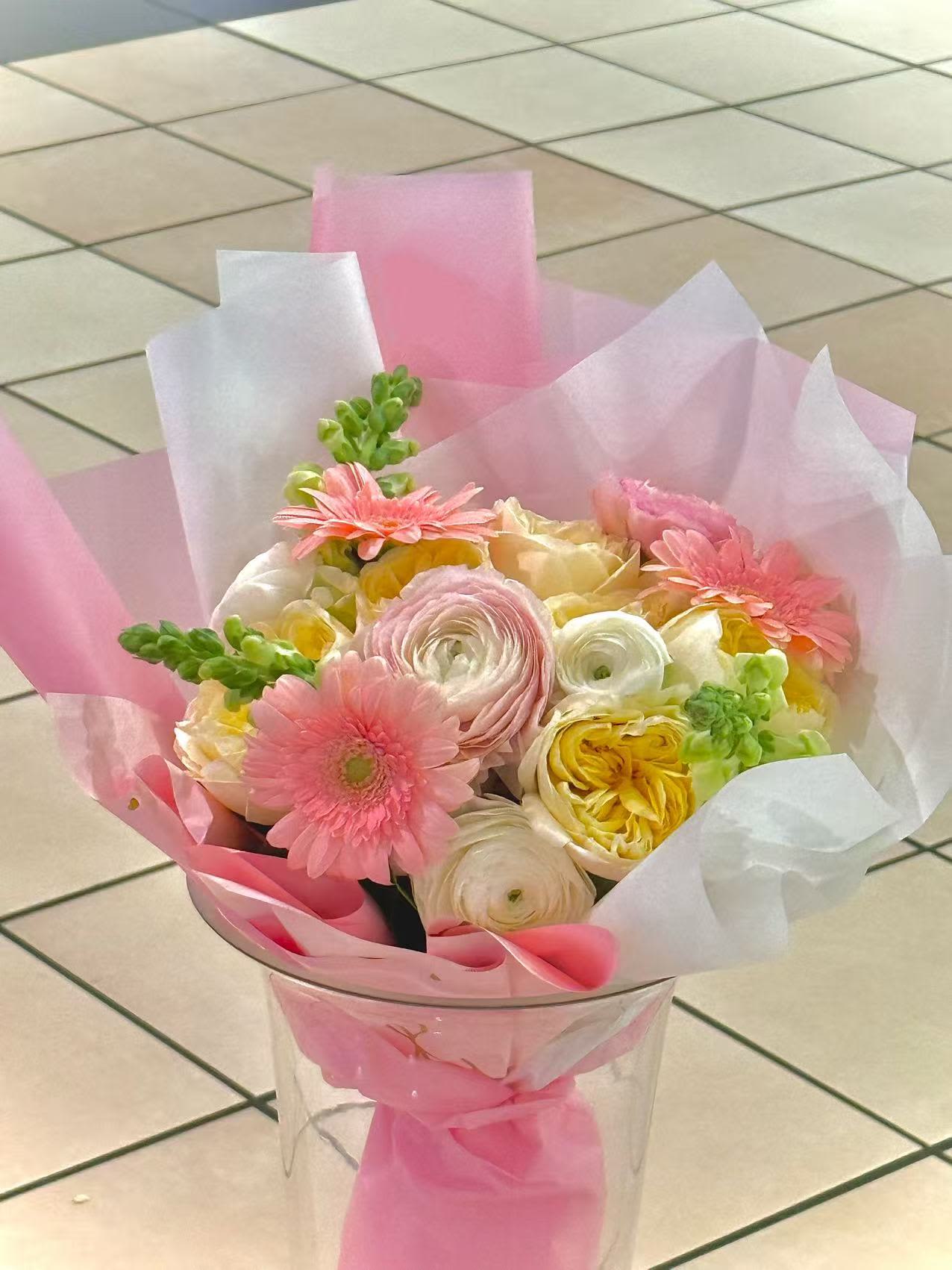 Pink and white bouquet with gerbera daisies and ranunculus in clear wrap