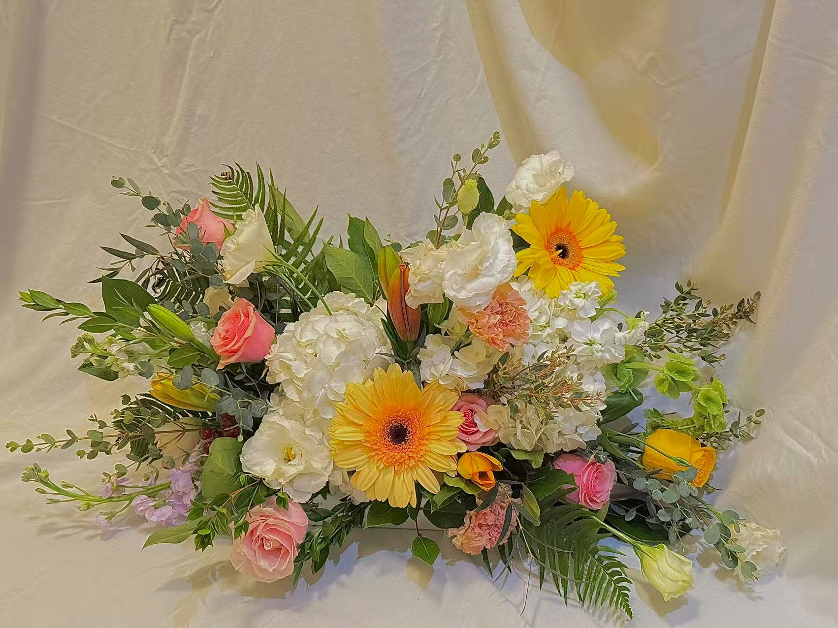 Mixed bouquet with yellow gerbera daisies, pink roses, and white blooms