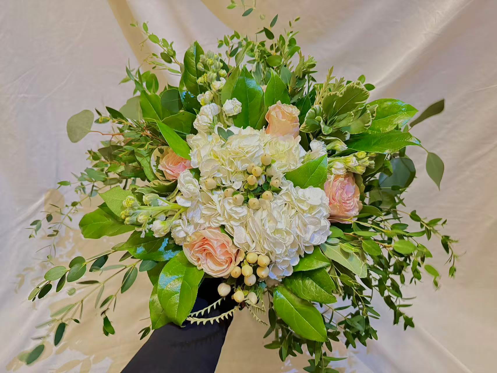 Bouquet of white hydrangeas and pale pink roses with greenery