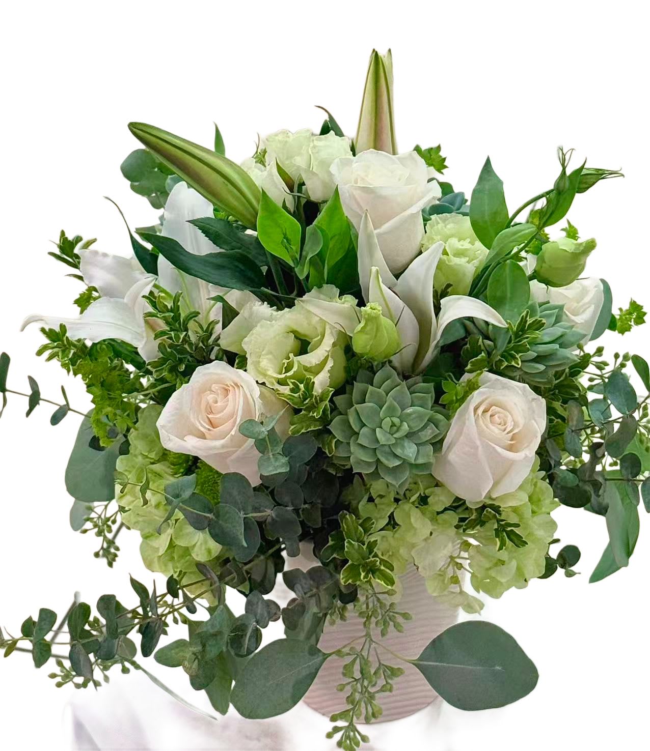 White roses and lilies arranged with green succulents in a vase