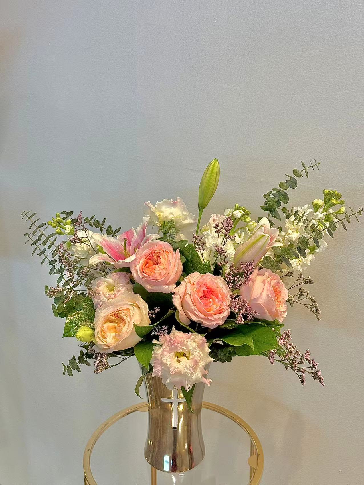 Pink roses and lilies arranged in a clear vase