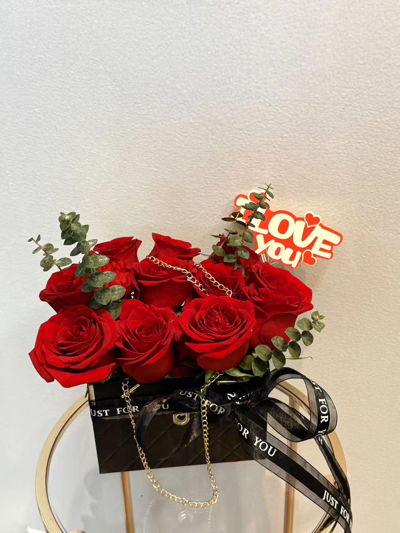 Red roses in a black gift box with a "Love You" topper
