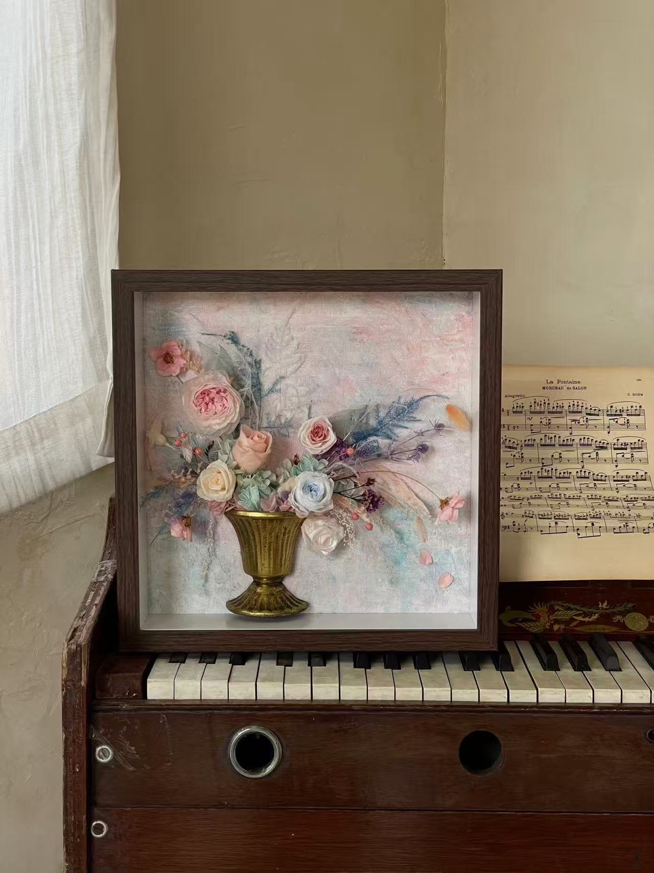 Framed floral arrangement with pastel roses in a gold vase