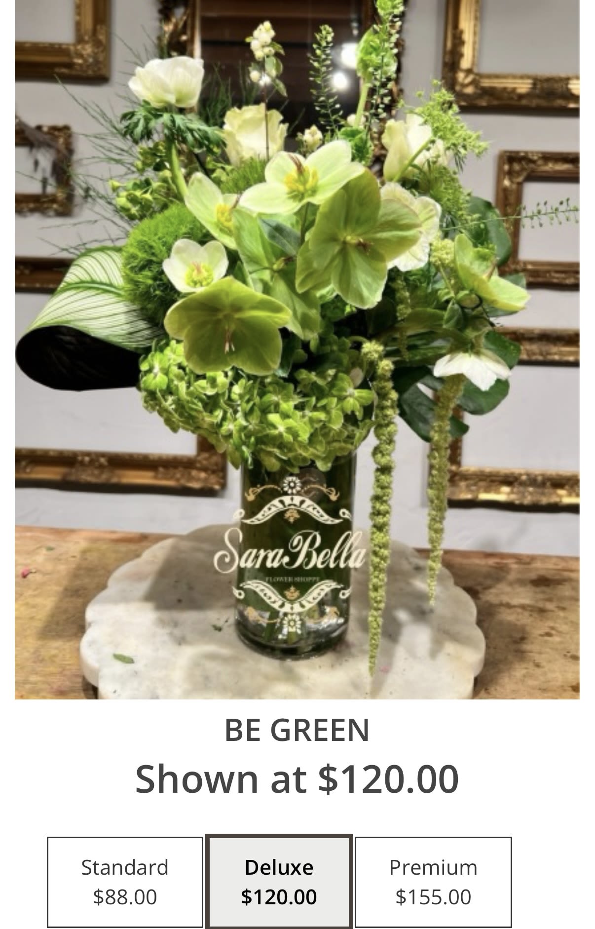 Green floral arrangement in a dark glass vase