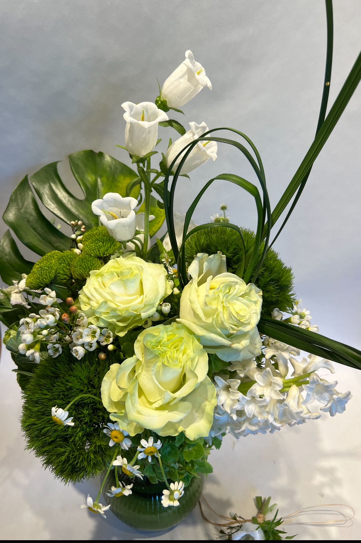GREEN LIFE - A modern, sculptural arrangement featuring with white campanola,soft green roses, and fresh seasonal blooms, accent with bold greenery and artistic lines.