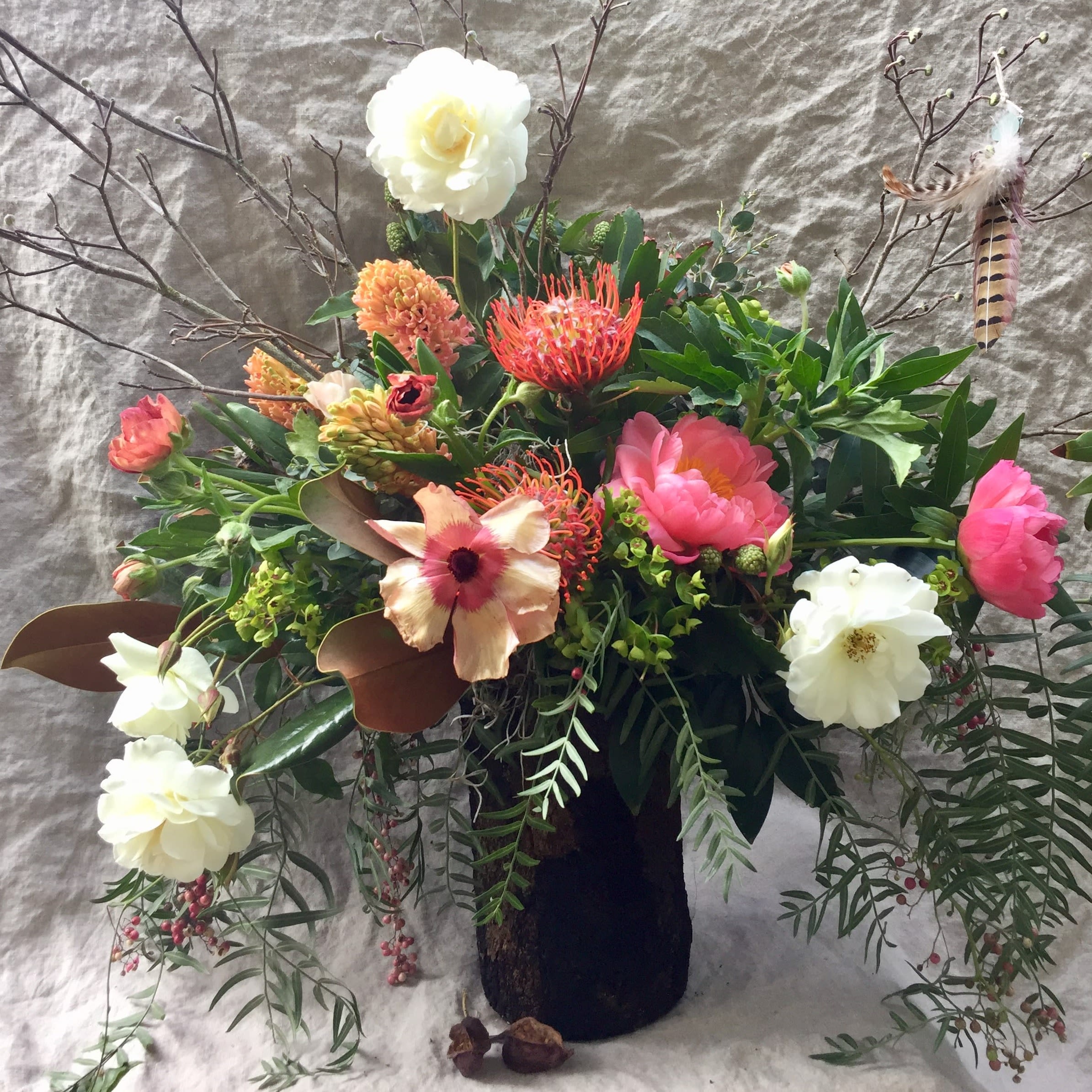 Mixed floral arrangement in a dark vase with white, pink, and orange blooms