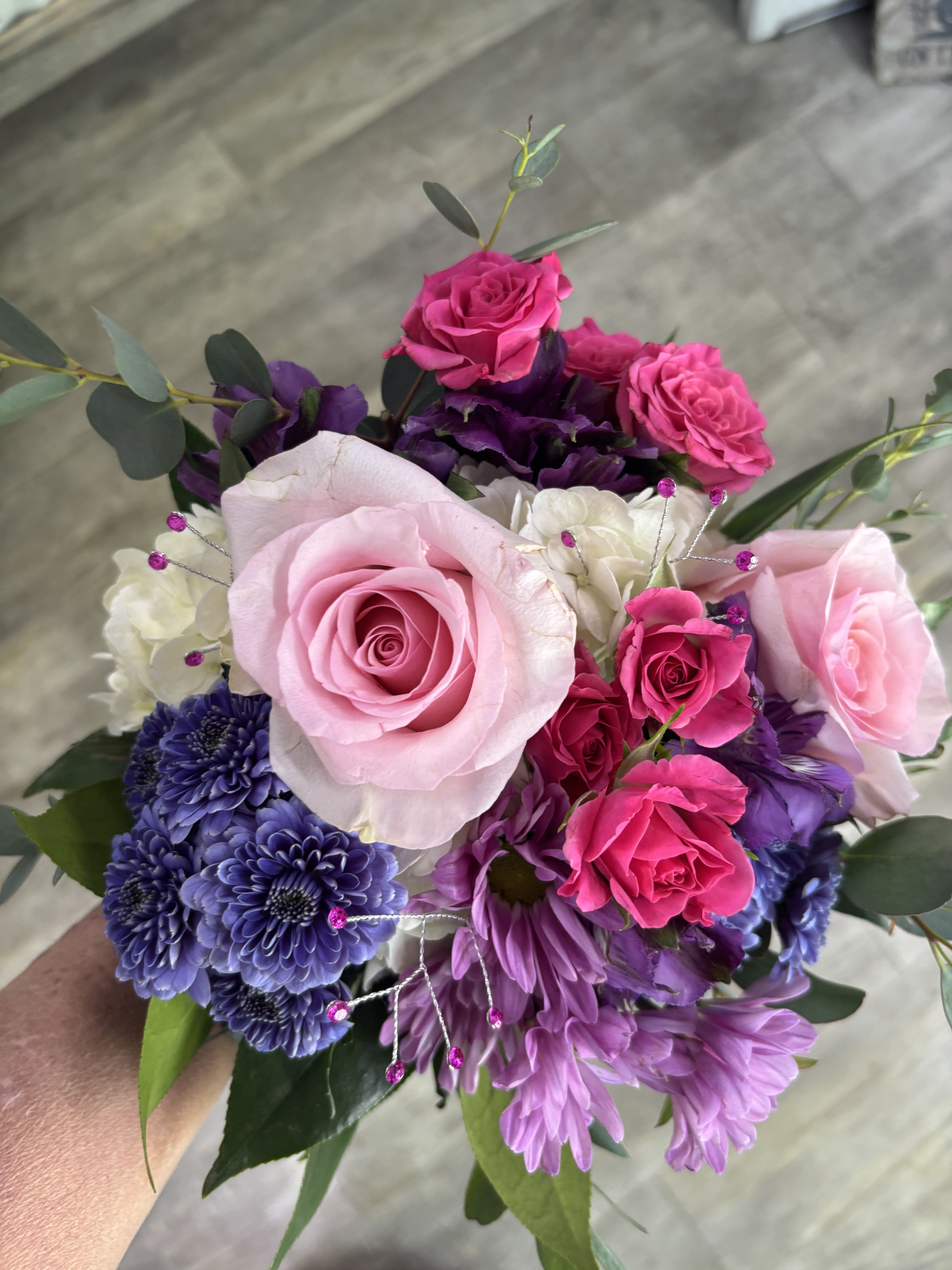 Mixed Flower Prom Bouquet  - Make prom night unforgettable with our Custom Mixed Flower Prom Bouquet, designed in fresh flowers to match your prom colors and personal style. This hand-tied bouquet features a beautiful blend of roses, seasonal blooms, fresh greenery, ribbon detail, and sparkling jewelry accents for a full, elegant, photo-ready look.  Every bouquet is custom created, making it the perfect choice for students who want something unique and coordinated with their dress. Simply include your preferred flower colors and jewelry accent colors in the Special Instructions at checkout. Whether you want soft pastels, bold brights, classic black and white, hot pink, royal blue, red, lavender, emerald, gold, silver, or a multi-color blend, we will design a bouquet that fits your vision.  Perfect for prom, homecoming, winter formal, spring formal, senior walk-ins, and dance photos. Each bouquet is professionally handcrafted by Aspen Tower Florist using fresh flowers and quality materials for secure carrying throughout the evening.  We proudly create custom prom flowers in Greensburg, Indiana, and surrounding communities including Rushville, Batesville, Shelbyville, North Vernon, Hope, Westport, and nearby areas. Matching corsages, boutonnières, and wristlets may also be available.  Order early during prom season for best flower availability and custom design options. Let Aspen Tower Florist create a one-of-a-kind bouquet that helps you arrive in style and stand out all night long.