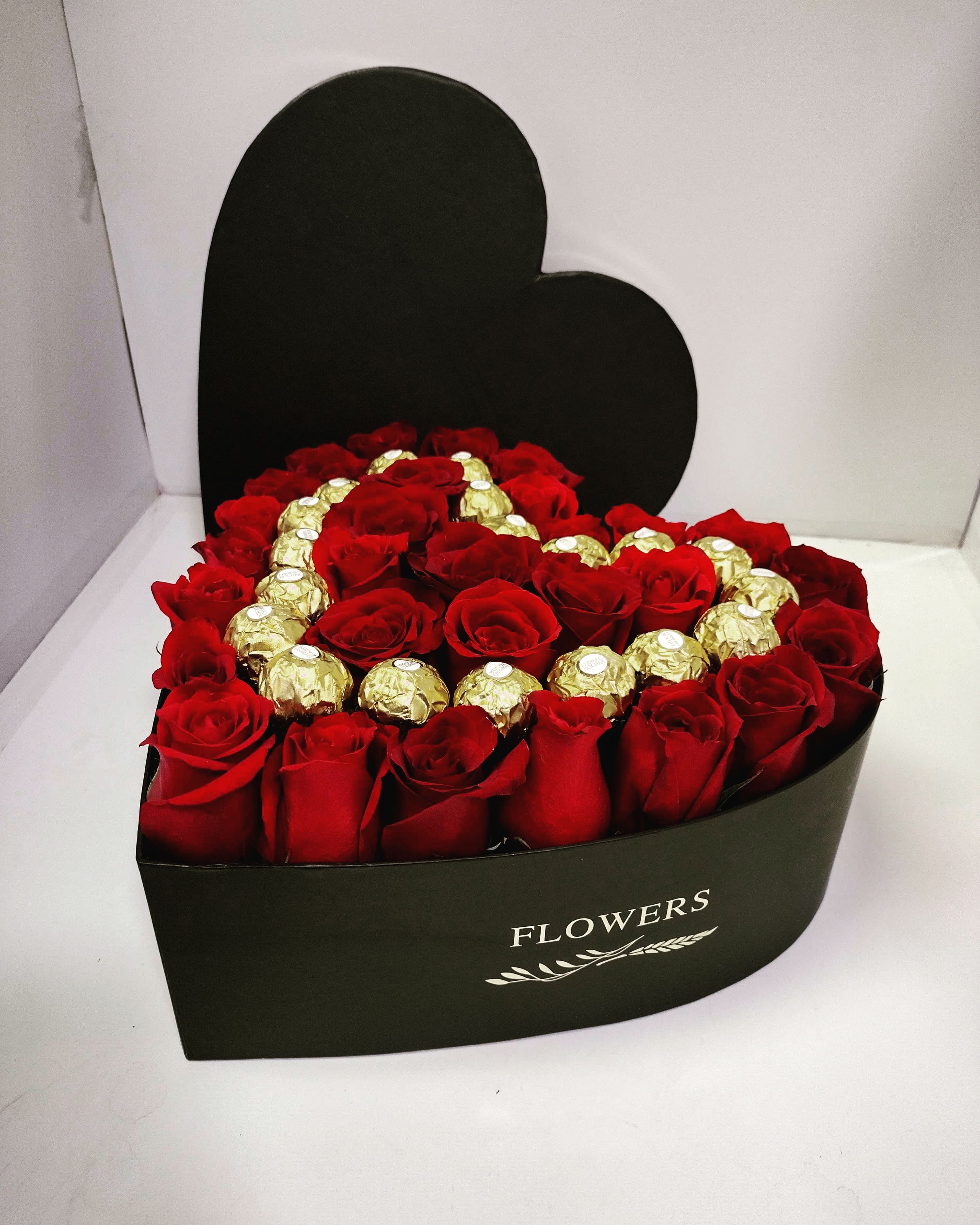 Heart-shaped box of red roses with gold-wrapped chocolates