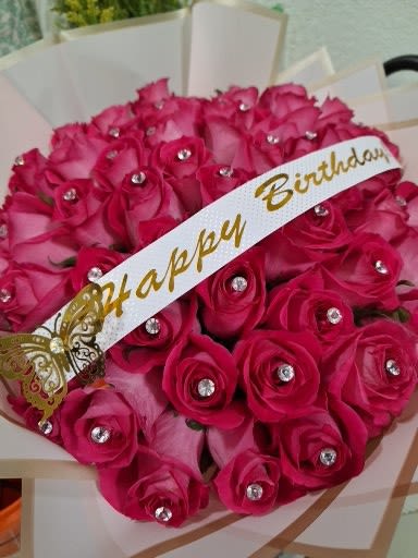 Bouquet of bright pink roses with a birthday ribbon