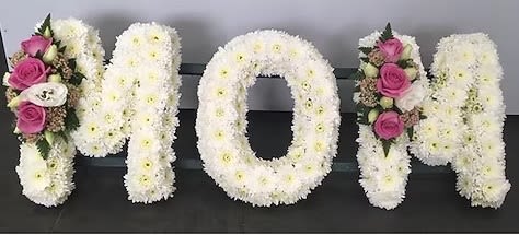 Floral letters spelling MOM in white and pink flowers
