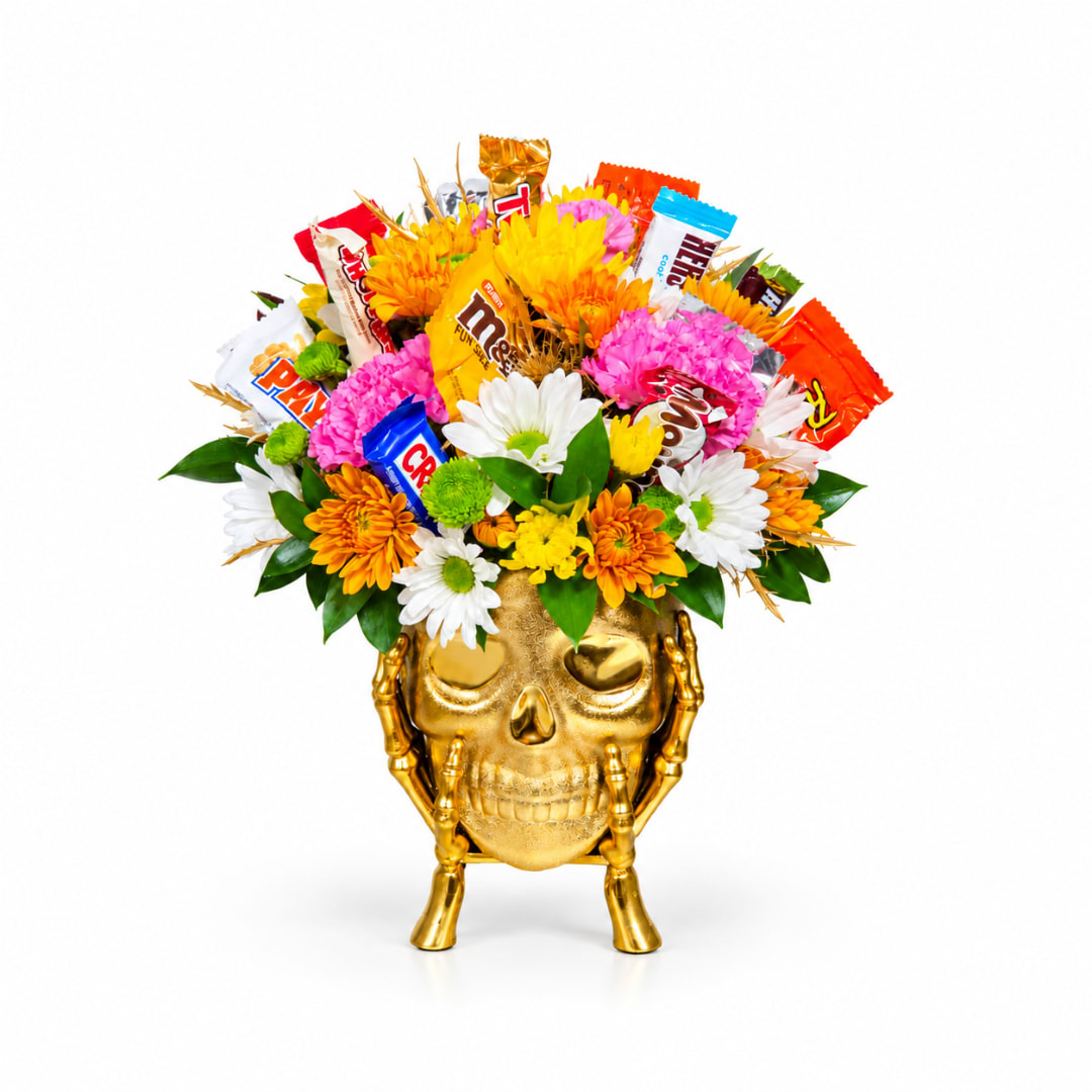 Flowers and candy arranged in a gold skull vase