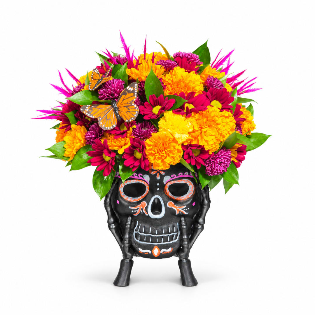 Colorful flower arrangement in a black skull-shaped vase with butterfly accents