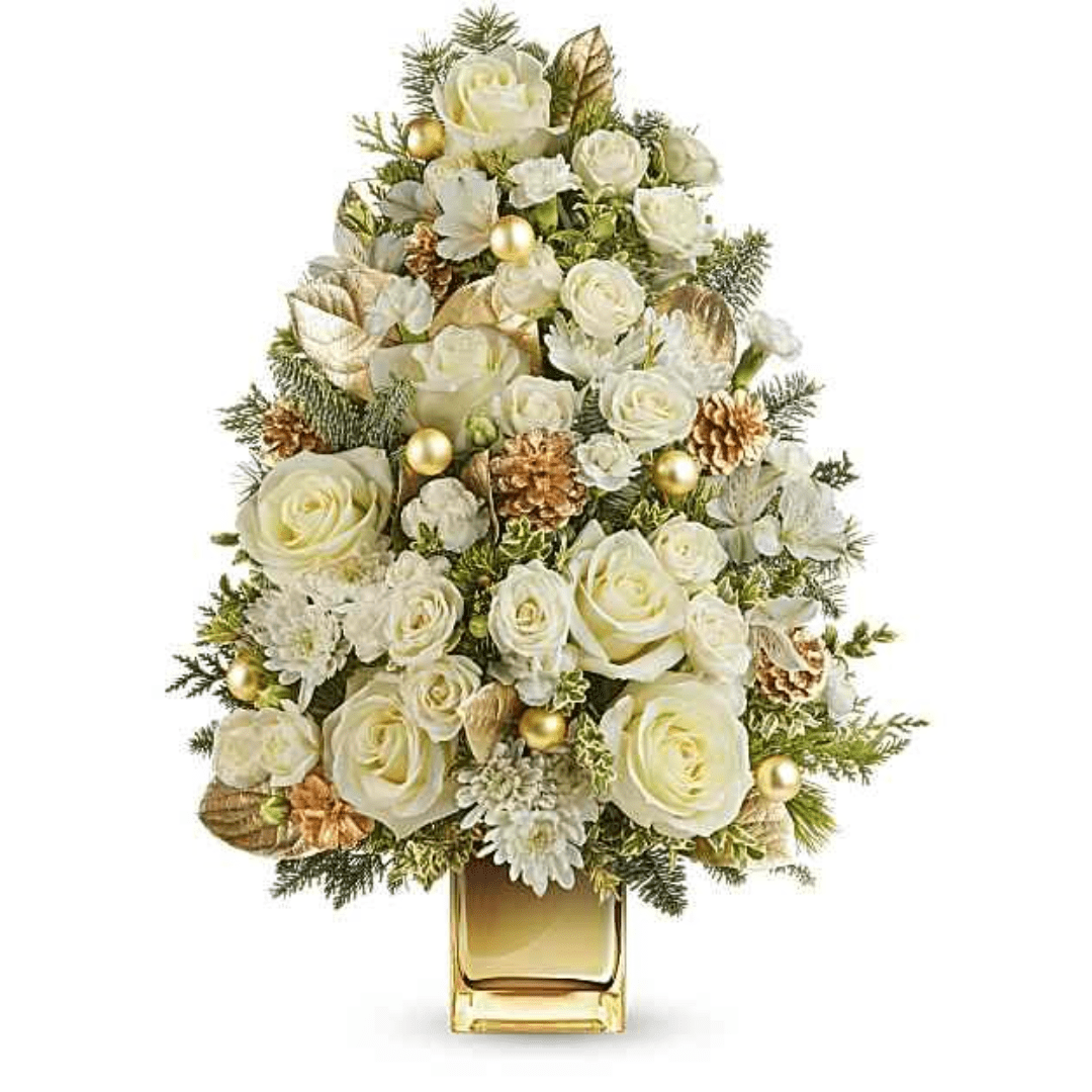White roses and winter greenery arranged in a gold vase