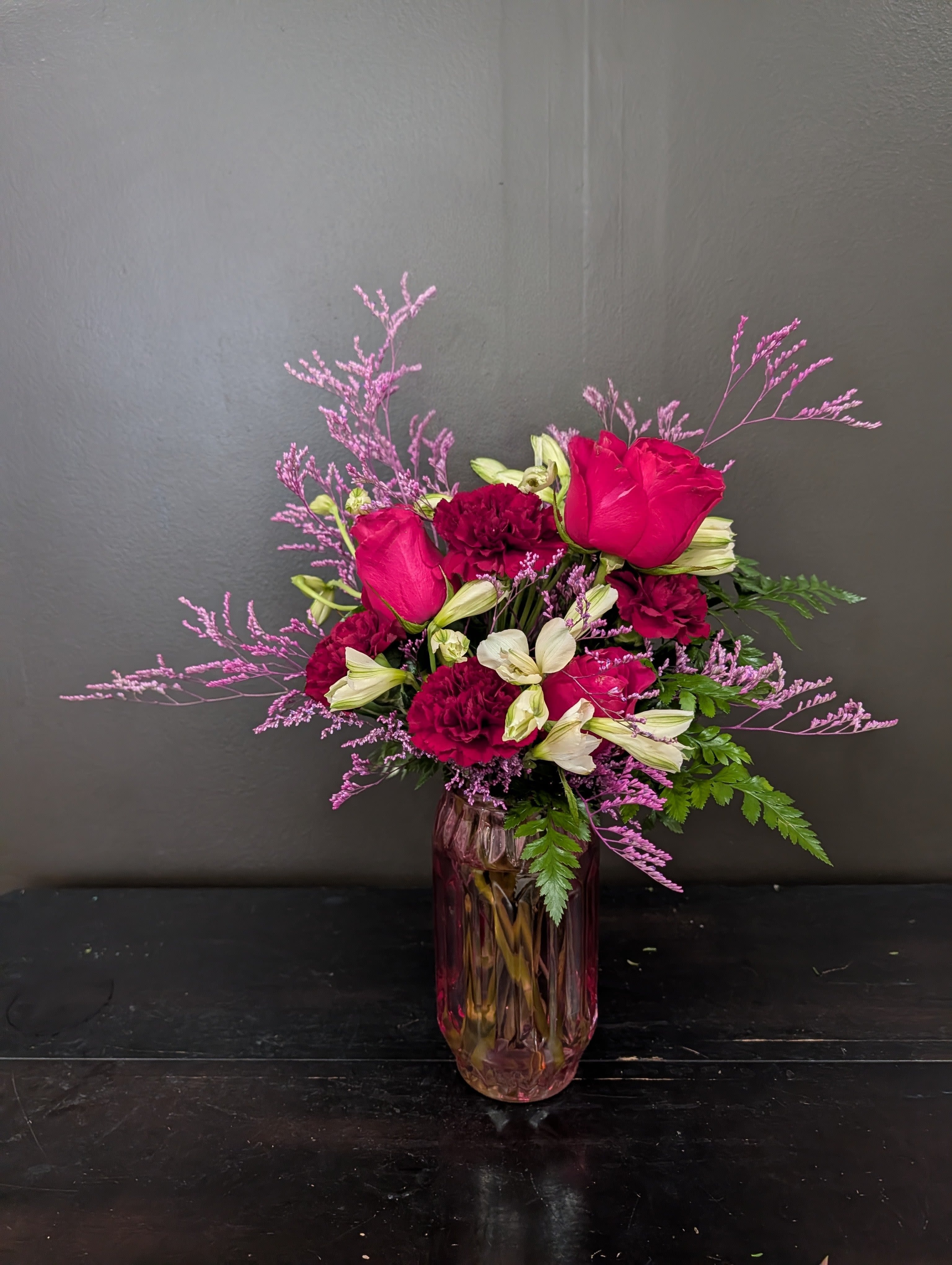 Pink roses and burgundy carnations in a glass vase