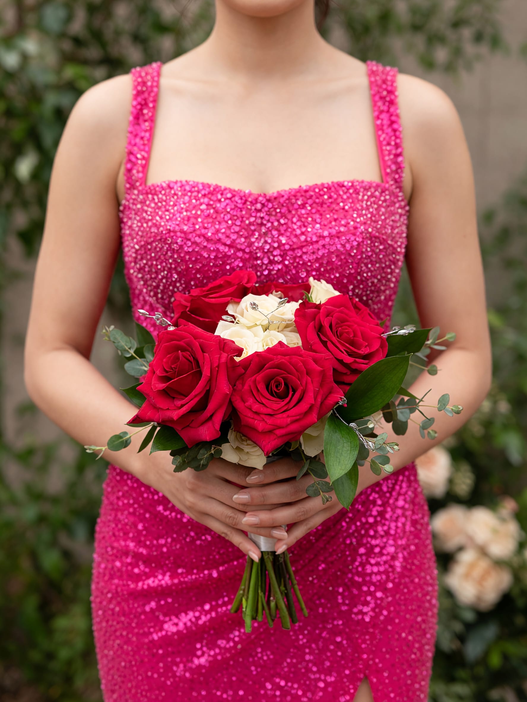 Pink and White Nosegay  - A bold, romantic hand-tied bouquet designed to make someone feel truly celebrated - the Pink and White Nosegay is a classic rose arrangement perfect for an anniversary, Valentine's Day, or as a wedding-related gift. Centered on large red roses with a tight cluster of white roses at the heart, this nosegay reads like a timeless declaration of love while the surrounding pink tones and greenery add a fresh, contemporary touch.  The arrangement pairs velvety red and crisp white roses with soft eucalyptus-like foliage for contrast and texture, finished with decorative wire accents and a neat bouquet wrap for a polished presentation. Compact and easy to hold, the design emphasizes the rich color contrast and formal silhouette that feels special without being fussy.  Give this to the person you're thinking of when you want them to feel seen and adored - it's the kind of bouquet that reads as intimate and elegant for romantic milestones or to mark a memorable celebration. Arrives wrapped and ready to present; keep stems in fresh water and trim an inch before placing to extend vase life.
